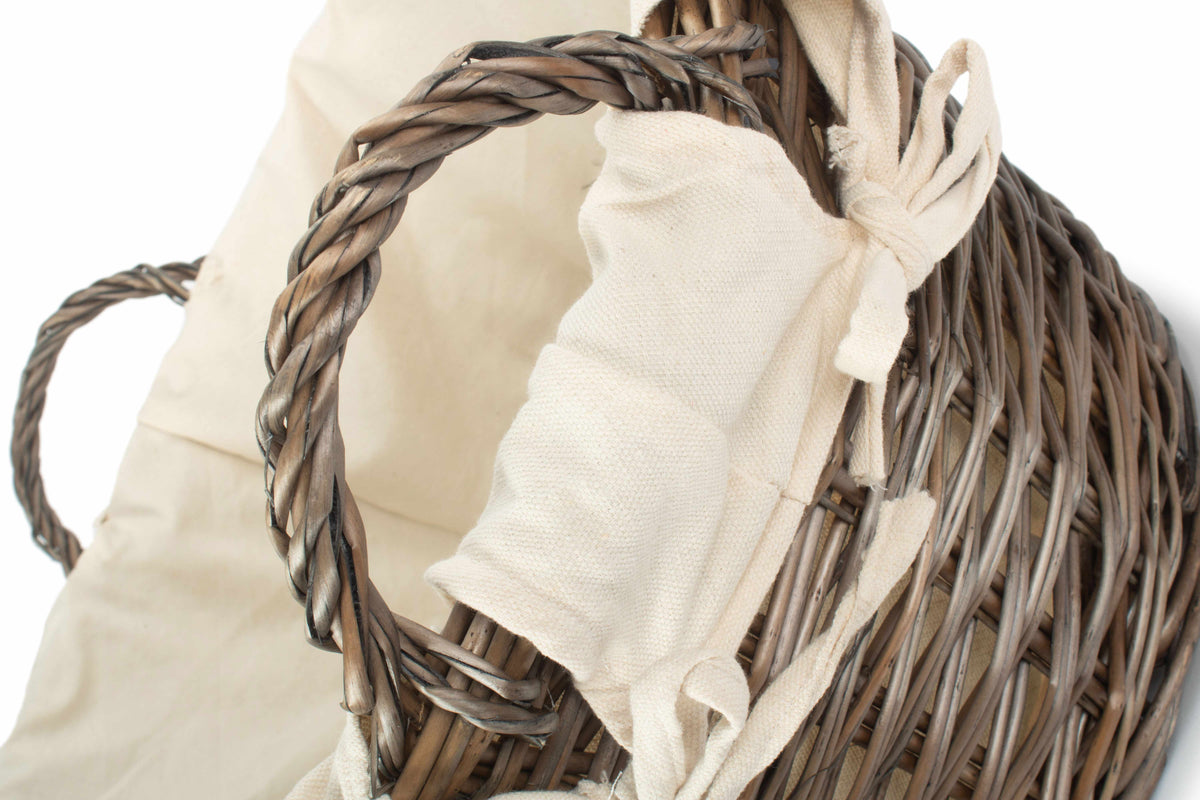 Antique wash willow laundry basket close-up showing the woven ear handle and white fabric lining tied around the rim