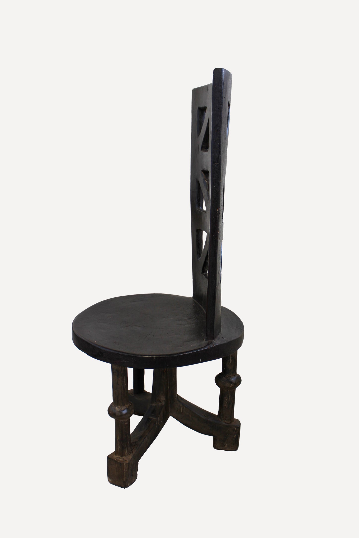 Hand-carved Makonde chair from Tanzania in side view showing its tall upright sculptural form