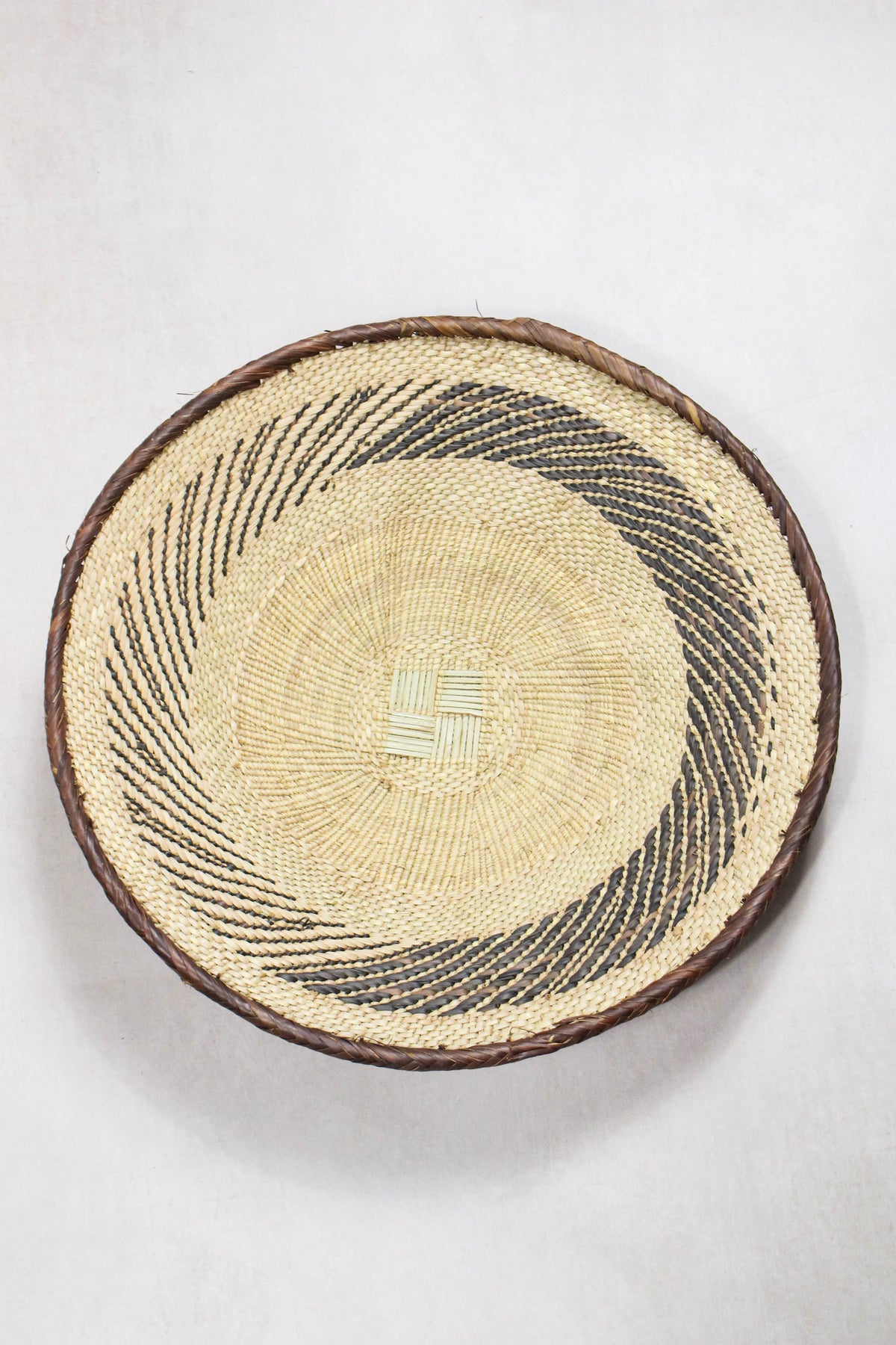 Handwoven Tonga wall basket from set No. 59 with circular natural woven pattern