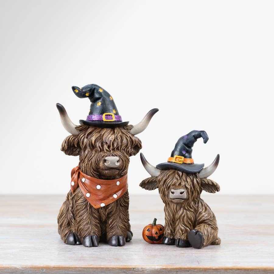 Halloween Highland Cow figurines with witch hats and pumpkin details displayed together