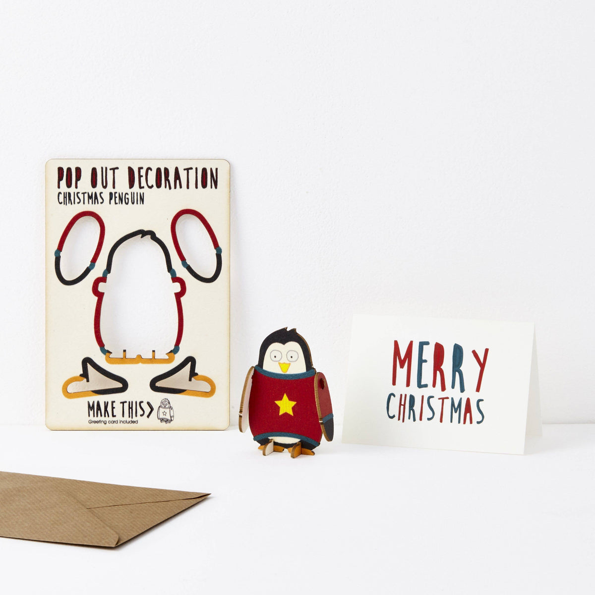 Pop Out Penguin Christmas Card showing the pop-out penguin decoration, Merry Christmas greeting card and brown envelope