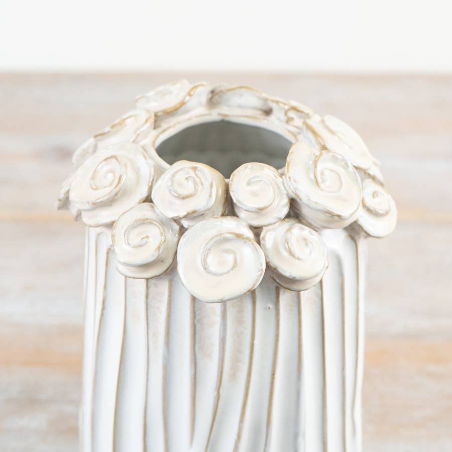Close-up of sculpted flower detailing around the rim of white ceramic vase