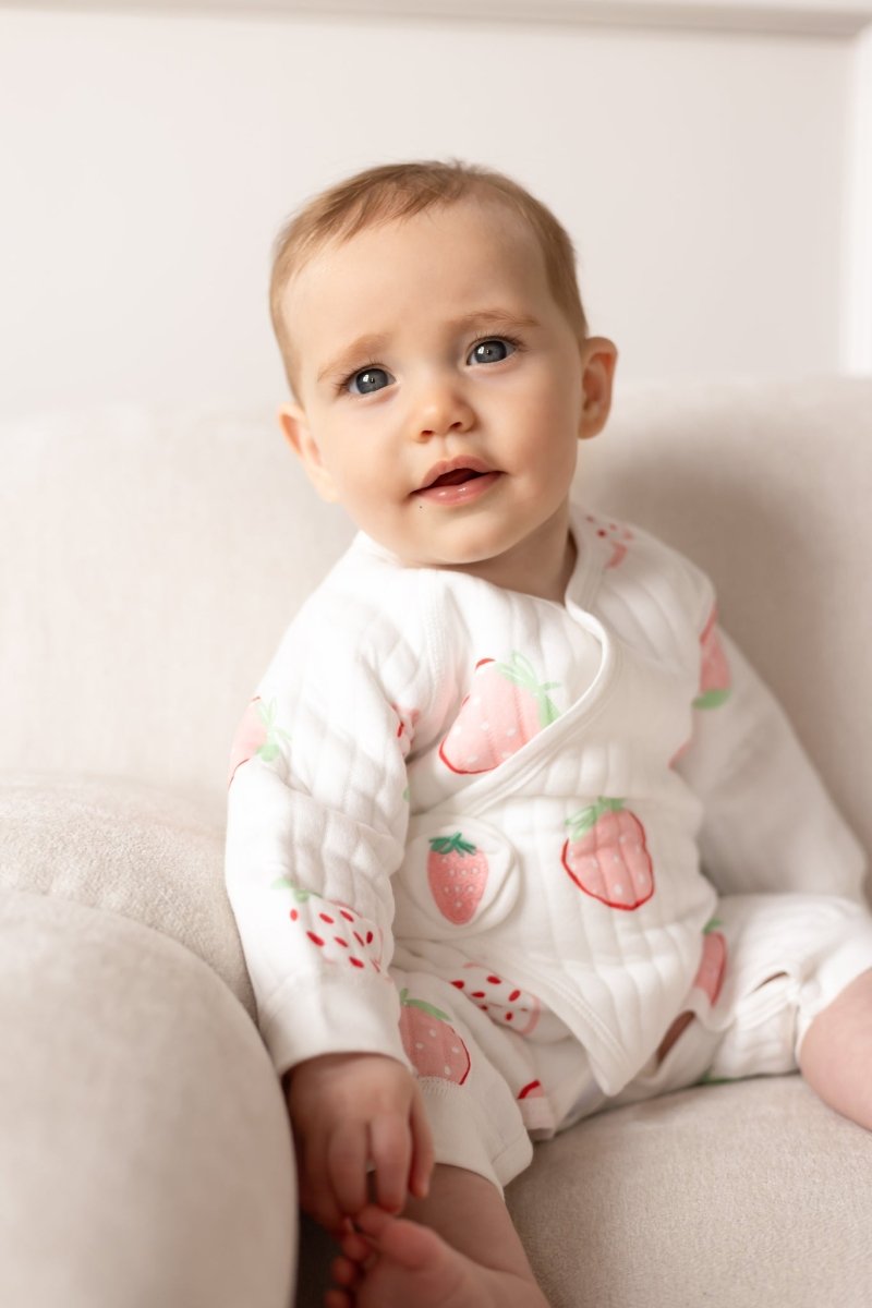 Baby wearing the Strawberry Bouclé Wrap Baby Grow Romper by Cozy Crew Club