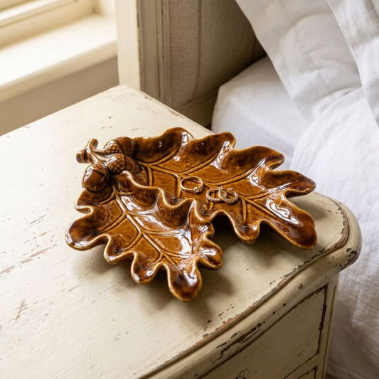Acorn & Leaf Ceramic Dish, 23cm, with glossy brown oak-leaf detailing displayed on an antique bedside table in a country bedroom.