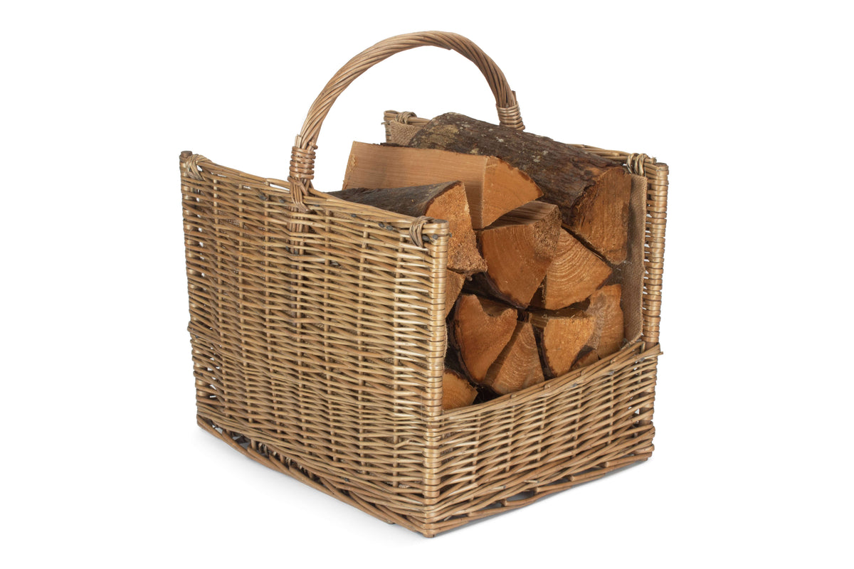 Antique wash willow open end log basket filled with firewood, showing its curved carry handle and hessian lining