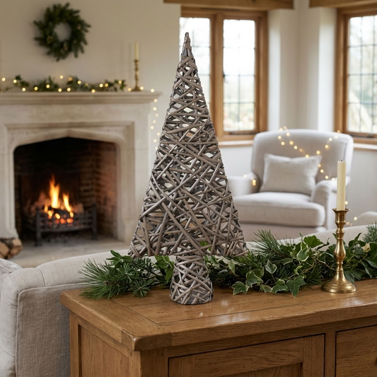 Antique Wash Willow Tabletop Christmas Tree displayed with festive greenery in a traditional country cottage sitting room with a stone fireplace.