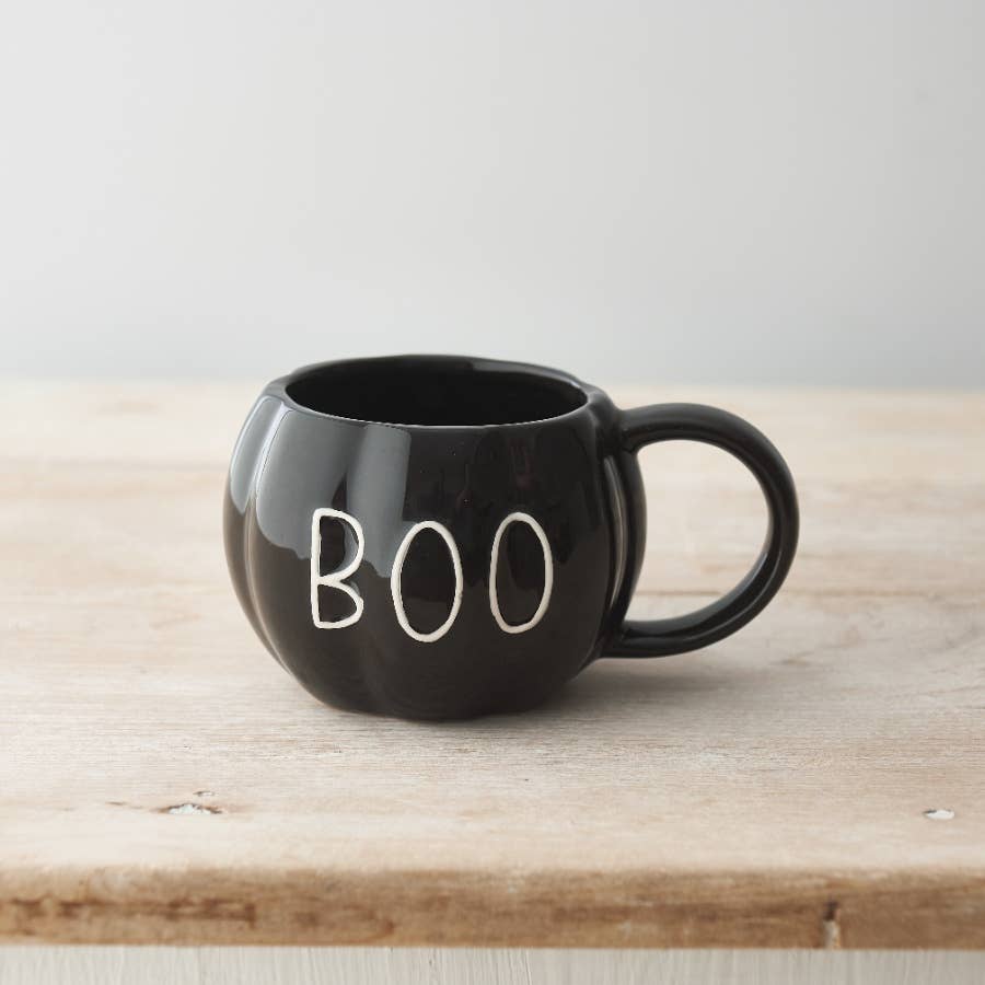 Black ceramic pumpkin-shaped mug with embossed BOO design