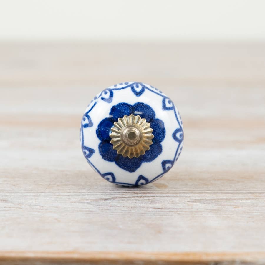 Front view of blue and white patterned ceramic door knob with antique bronze-coloured centre