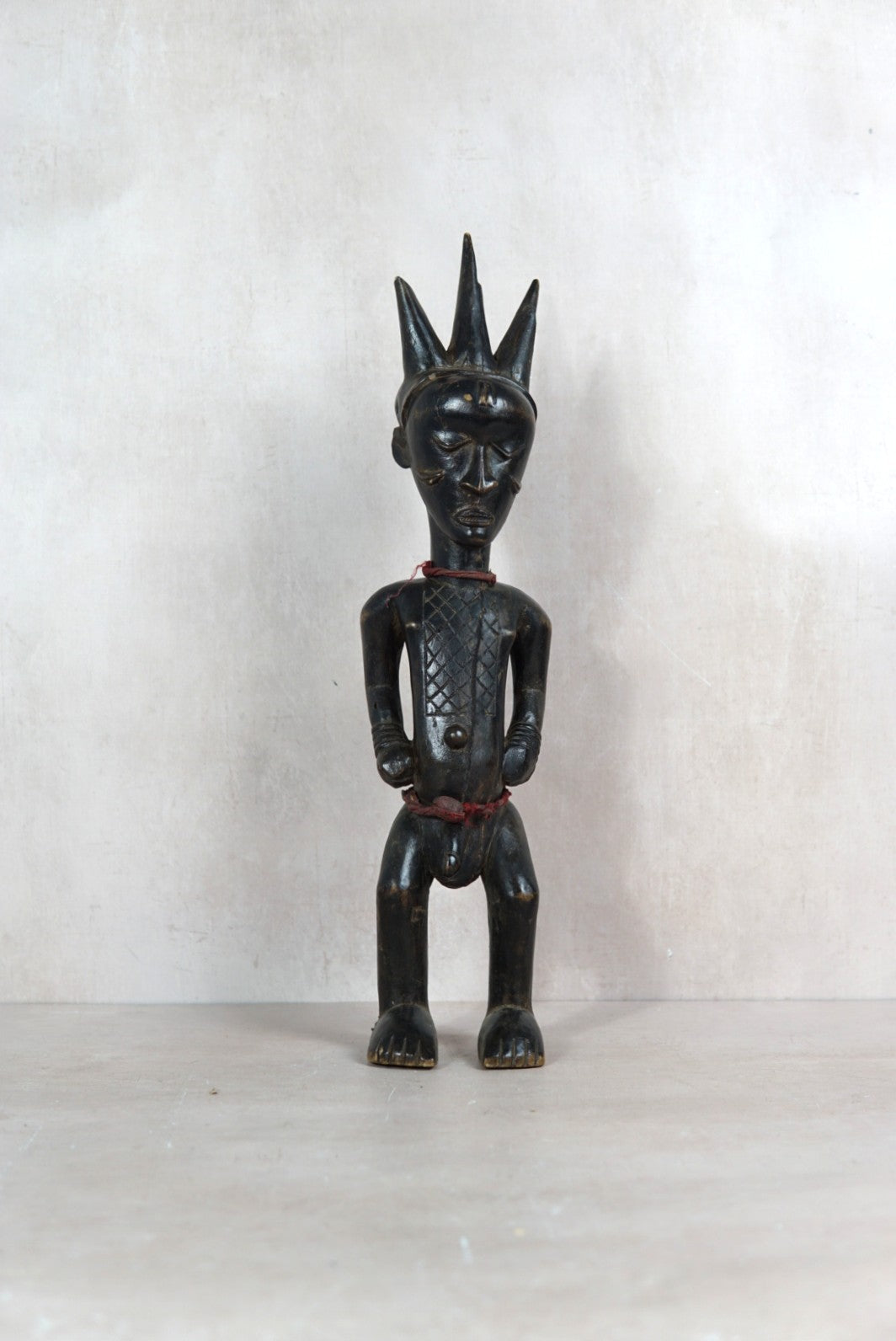 Baule carved male figure sculpture 118.1 from the Ivory Coast with three-pointed coiffure and deep dark patina

