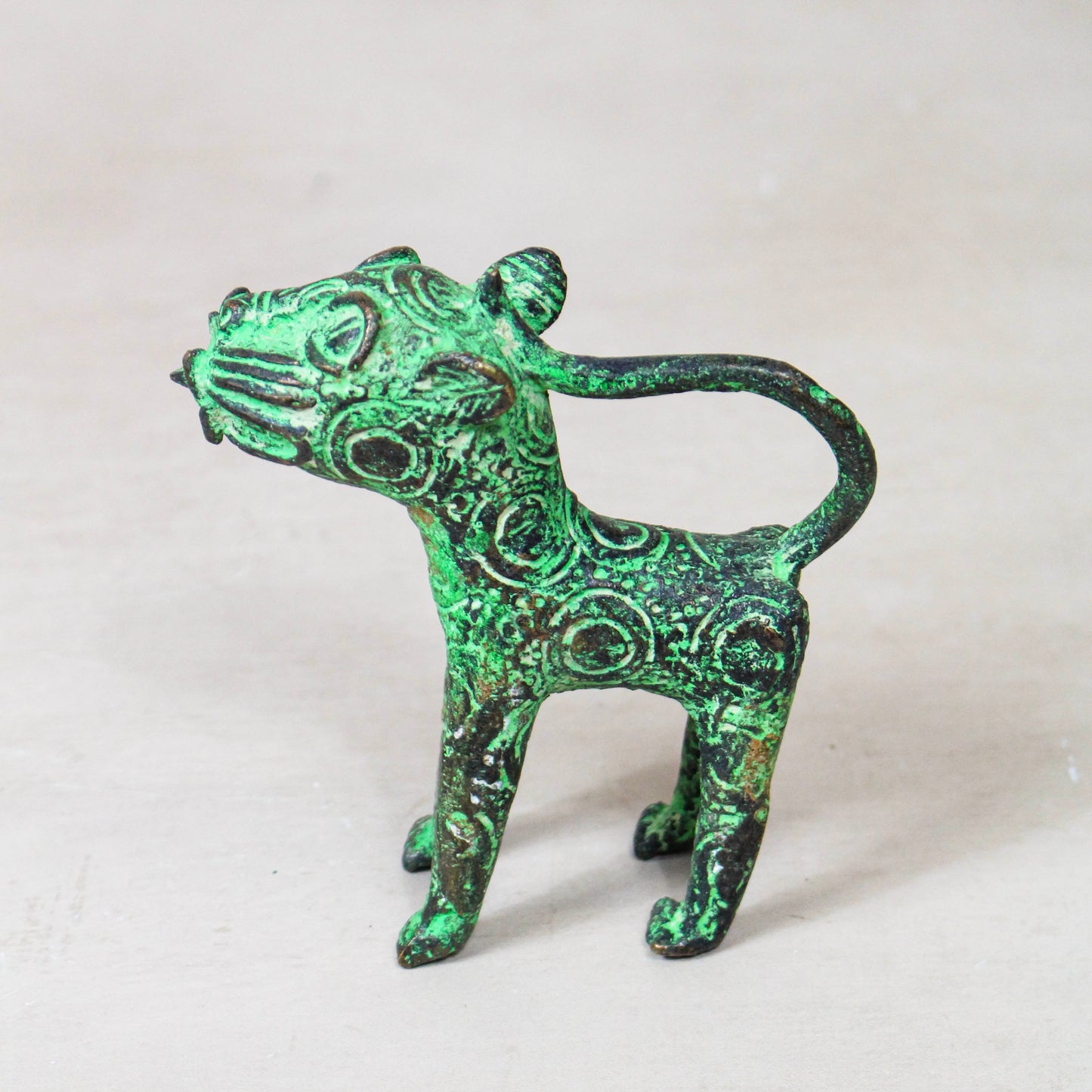 Benin bronze leopard sculpture 56.24 shown from the side, with aged green bronze finish
