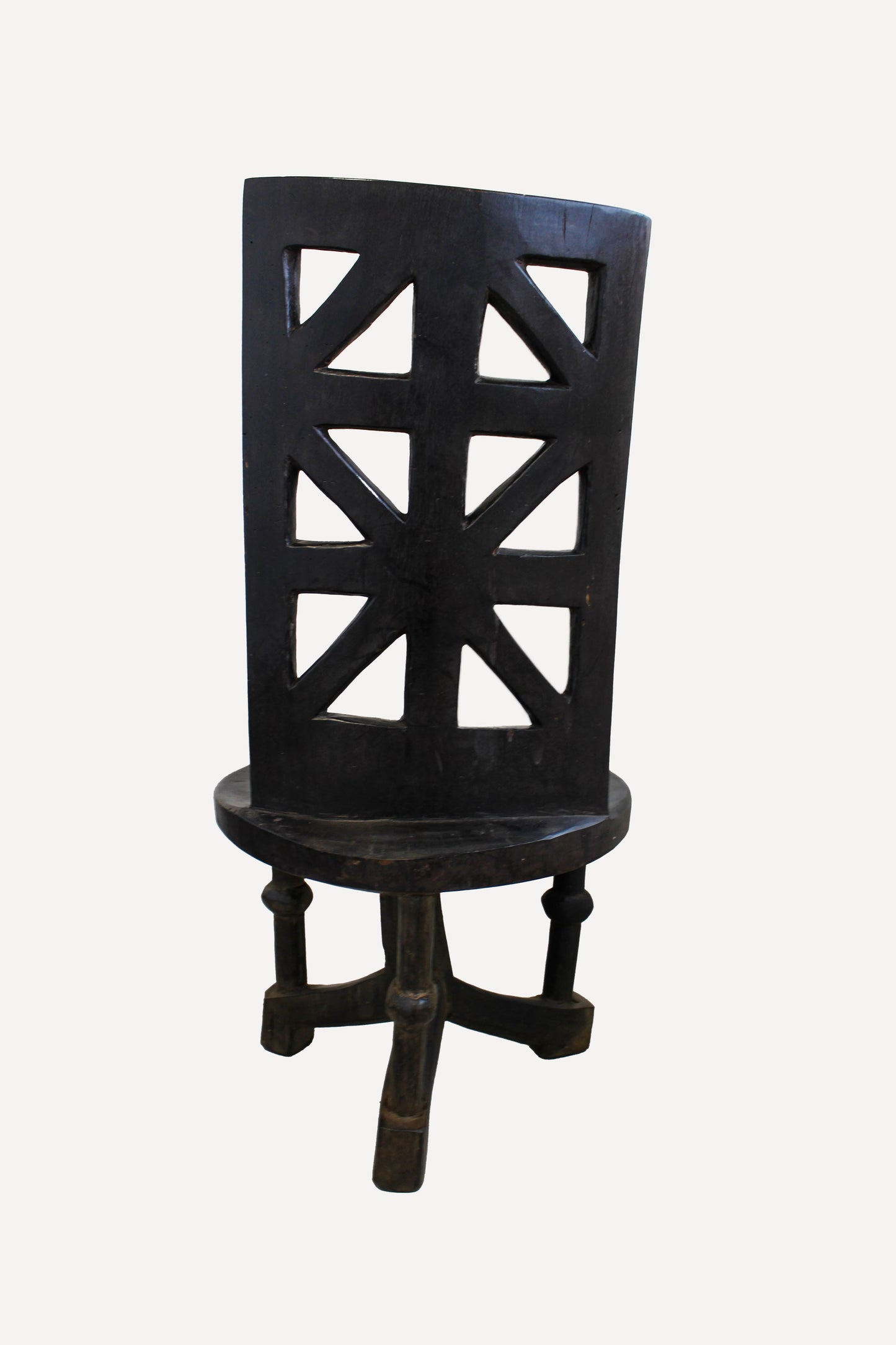 Hand-carved Makonde chair from Tanzania viewed from the rear showing the geometric carved backrest

