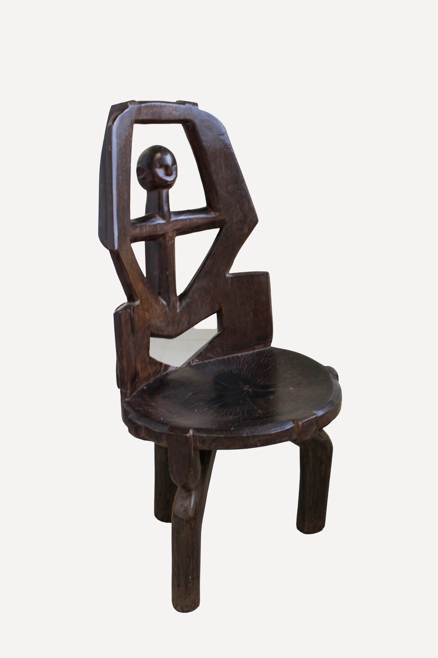 Hand-carved Makonde chair from Tanzania 242.4 viewed at an angle showing its sculptural seat and open back
