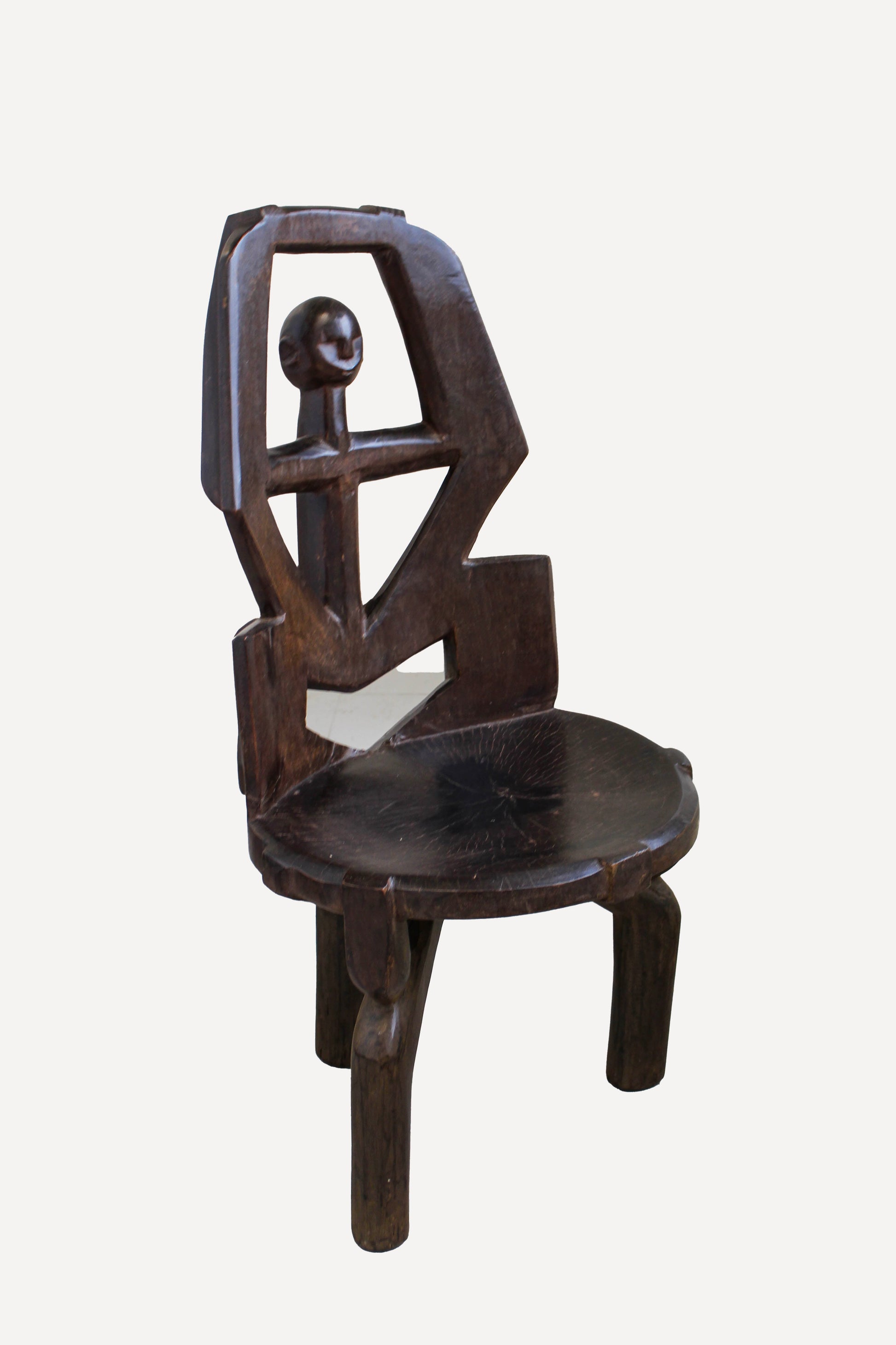 Hand-carved Makonde chair from Tanzania 242.4 viewed at an angle showing its sculptural seat and open back
