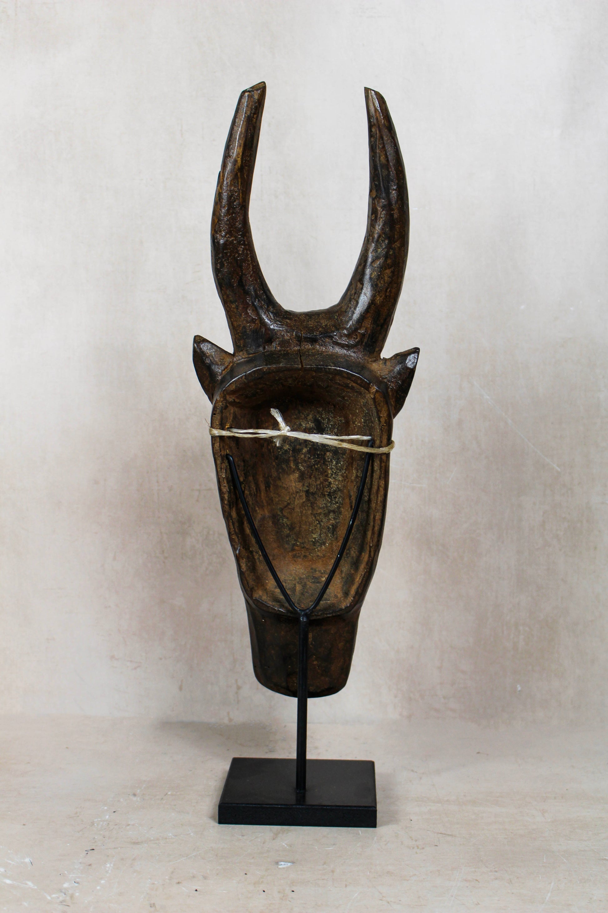 Mali bull mask 196.4 rear view with tall curved horns and display stand.