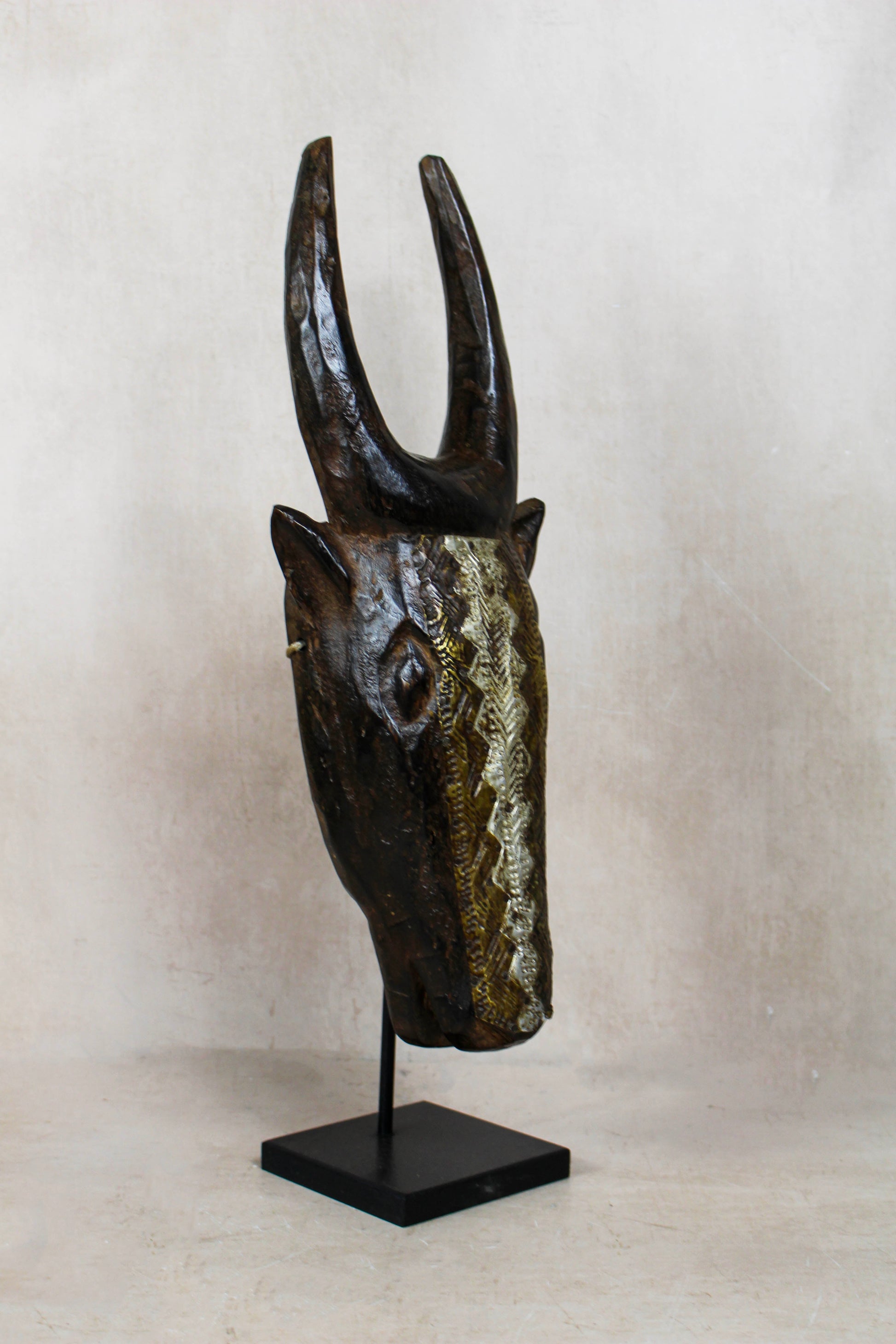 Mali bull mask 196.4 in side view showing the long carved snout, upright horns and repoussé metal detailing
