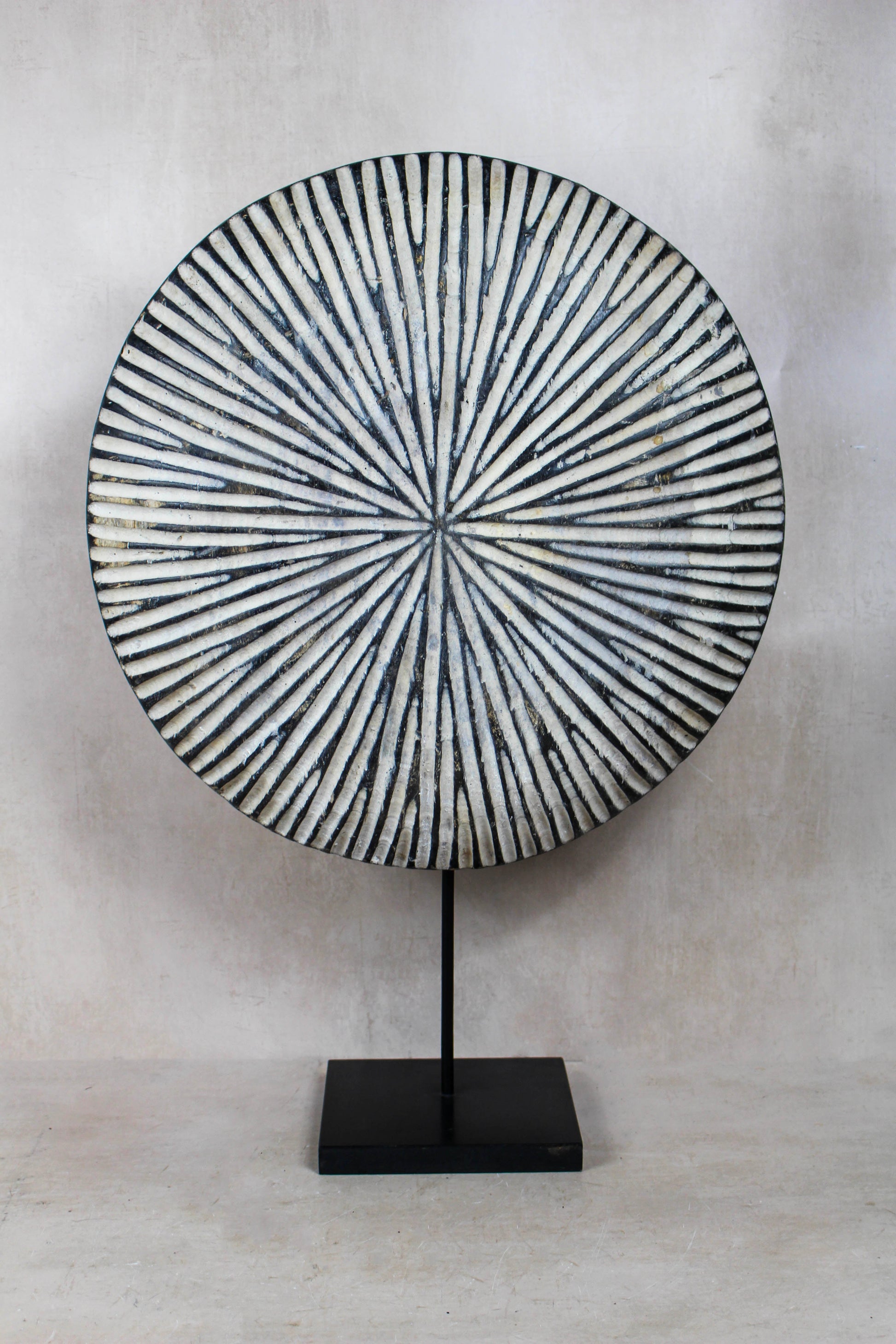 Round Cameroon shield 161.3 with bold geometric pattern displayed on a black stand
