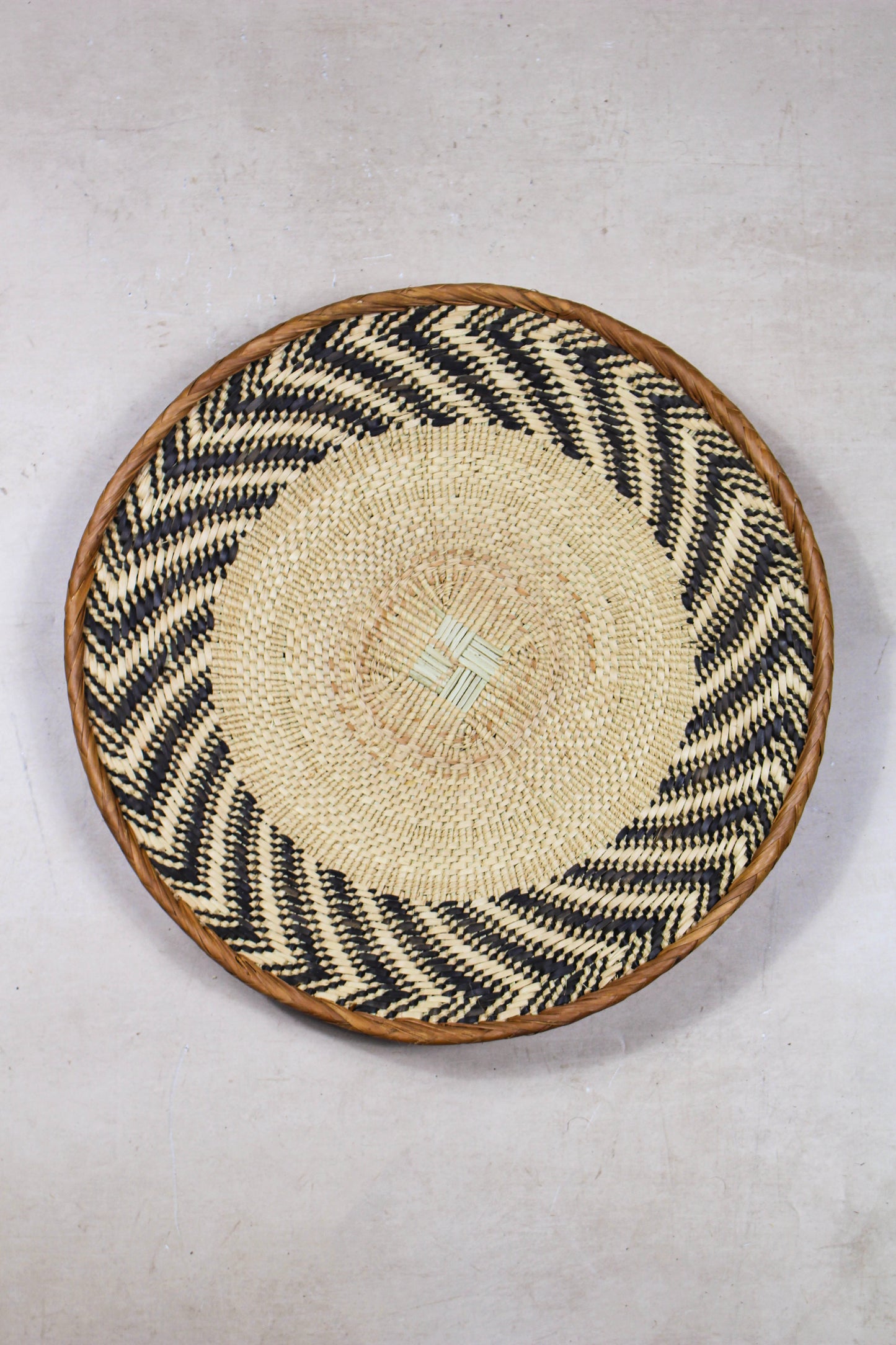 Handwoven Tonga wall basket from set No. 27 with dark natural geometric pattern
