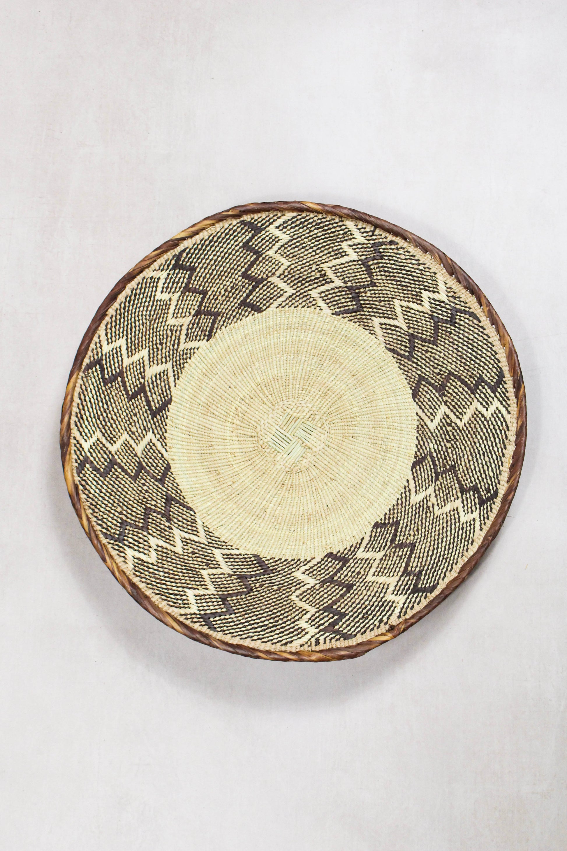 Handwoven Tonga wall basket from set No. 59 with natural geometric woven pattern
