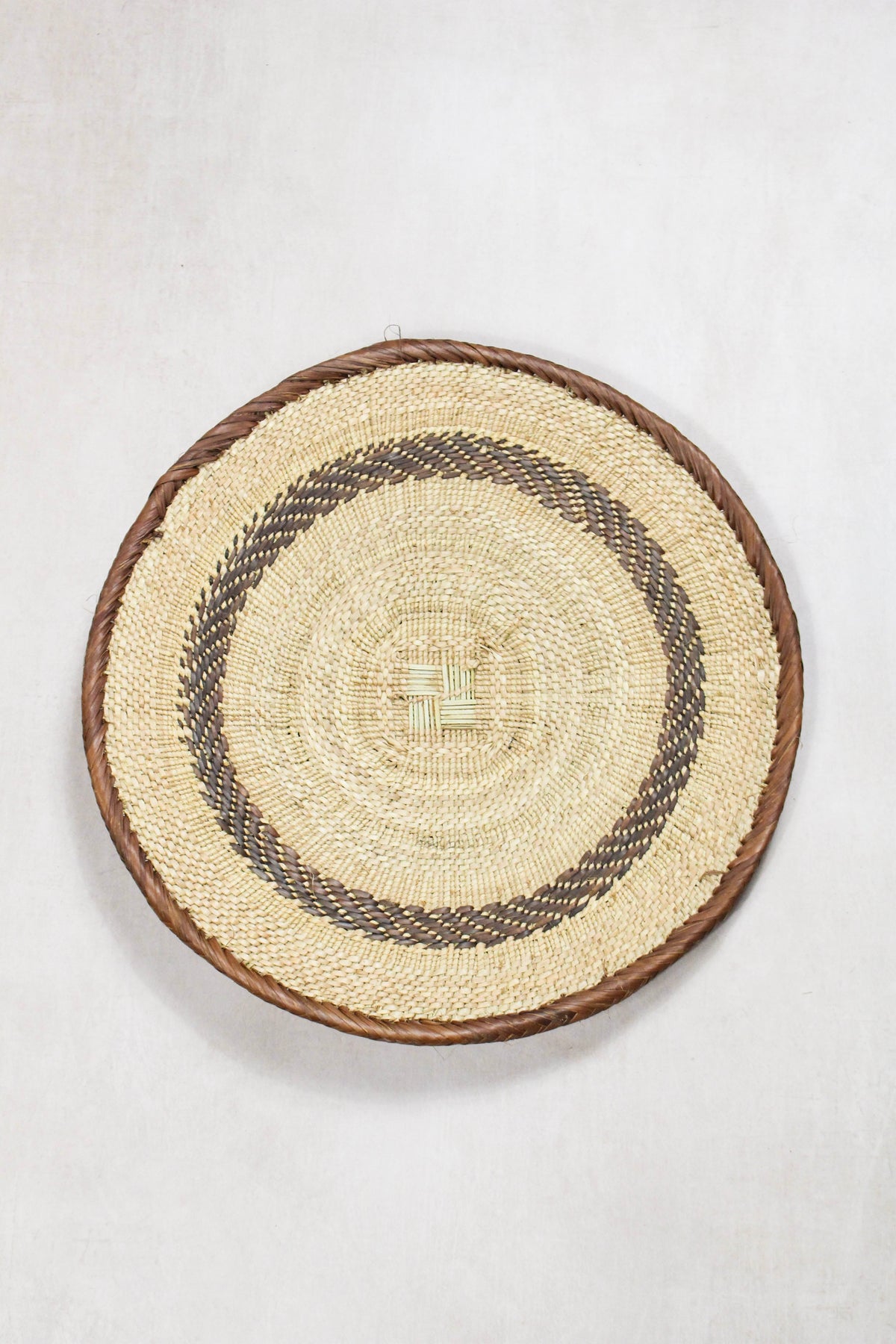 Handwoven Tonga wall basket from set No. 67 with natural circular woven detailing
