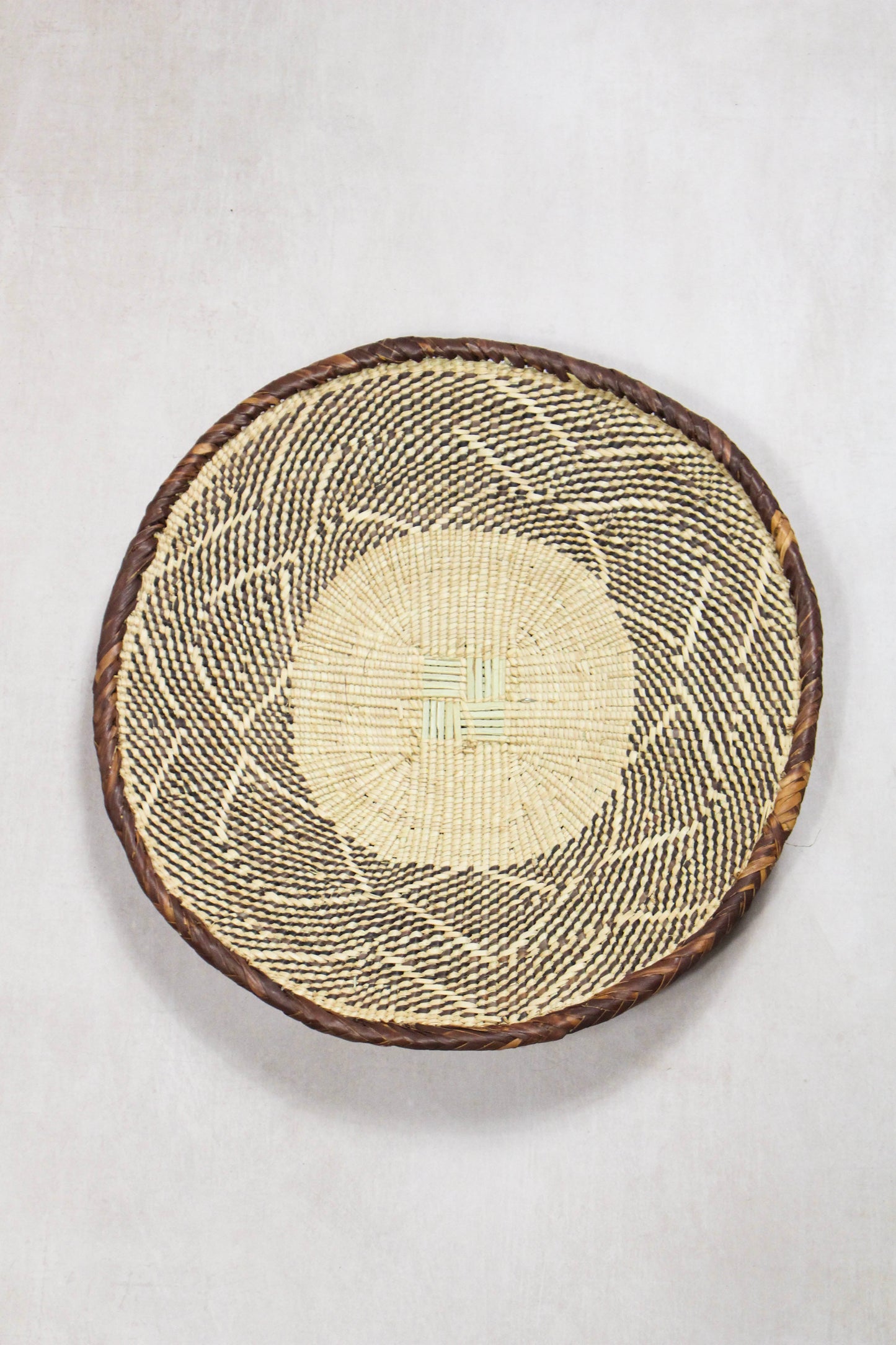 Handwoven Tonga wall basket from set No. 67 showing naturally dyed woven pattern