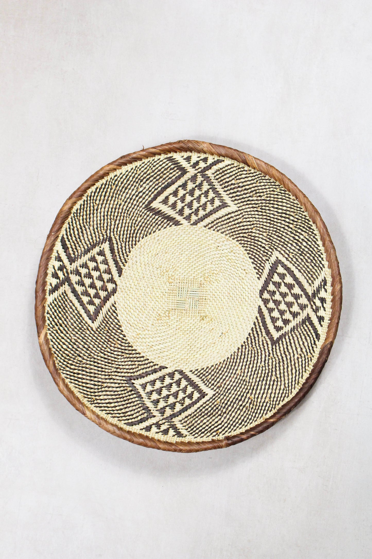 Handwoven Tonga wall basket from set No. 80 with natural dark woven border
