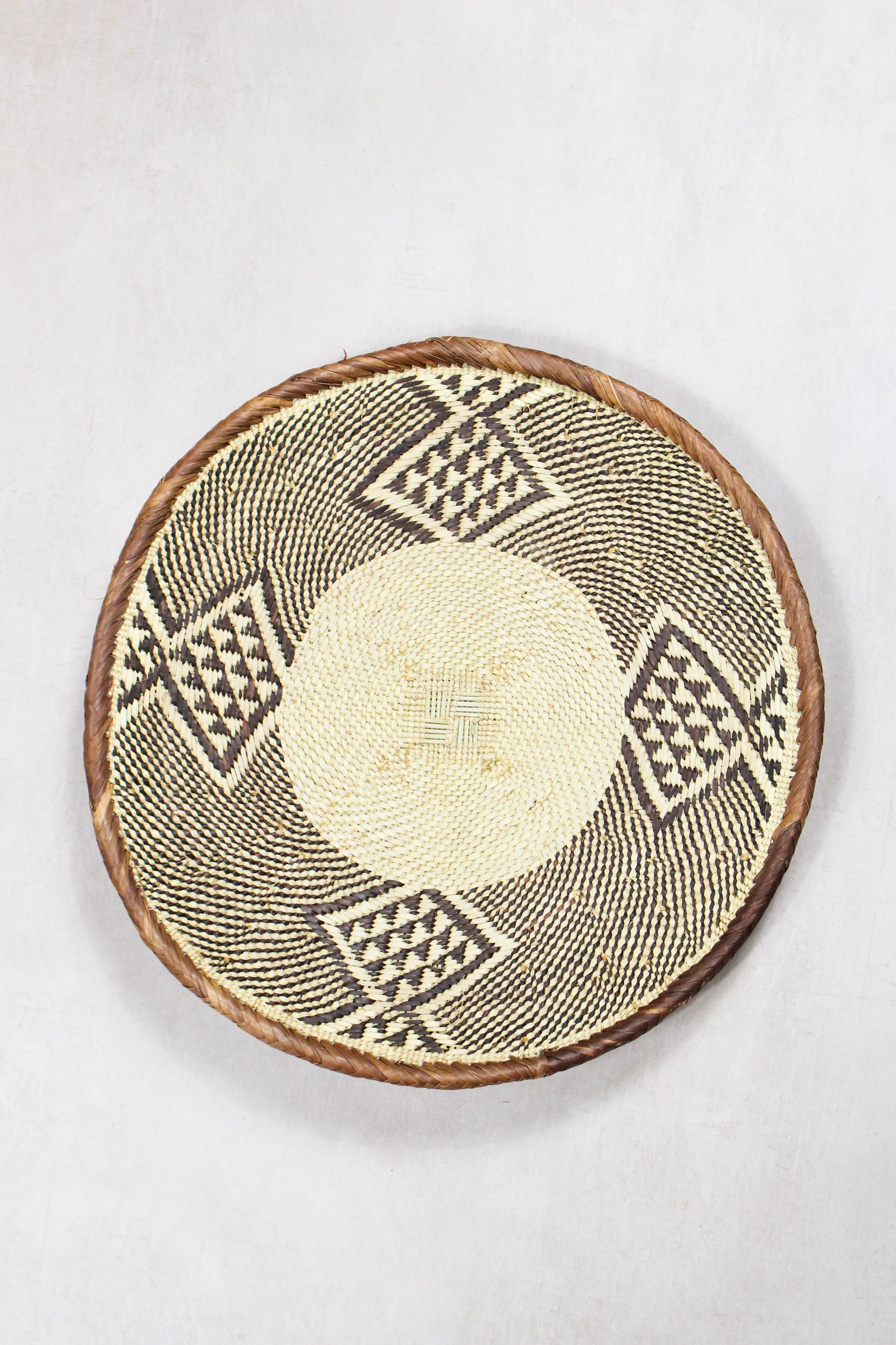 Handwoven Tonga wall basket from set No. 80 with natural dark woven border
