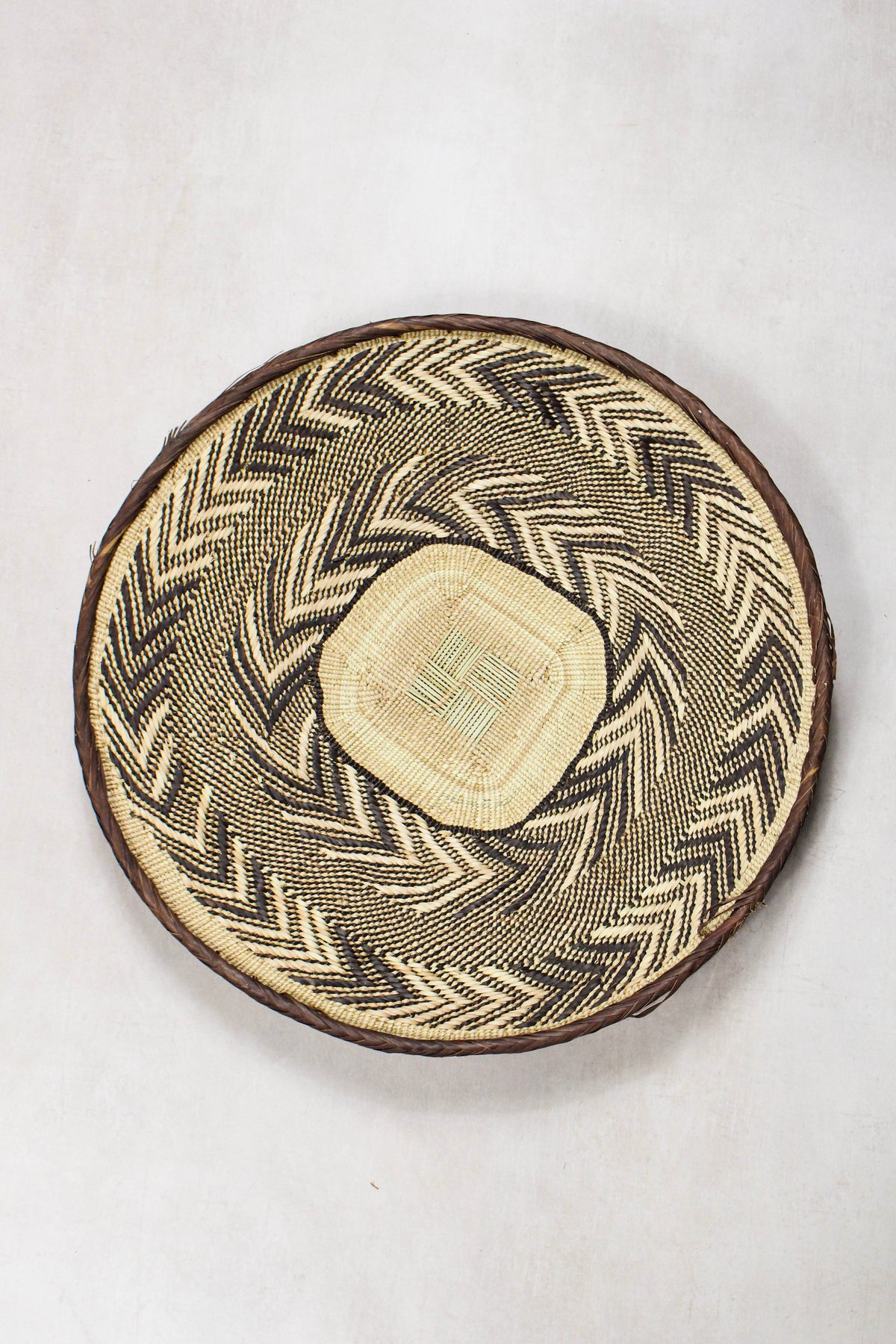 Handwoven Tonga wall basket from set No. 90 with dark geometric woven pattern
