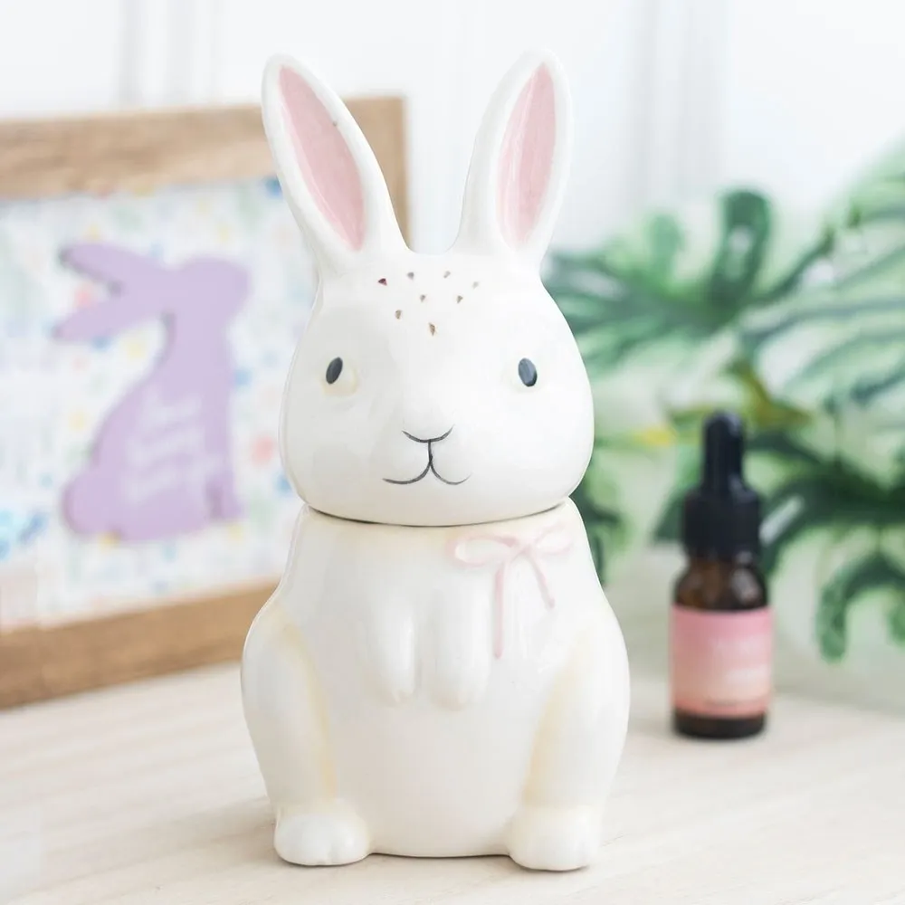 Bunny shaped ceramic oil burner displayed on a shelf with home décor, perfect for fragrance oils and wax melts.