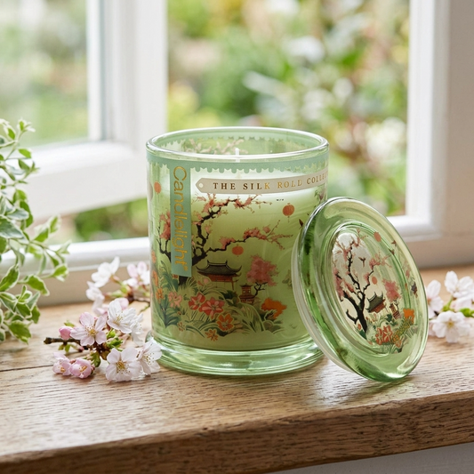 Candlelight Silk Road Chengdu large glass jar candle on a rustic cottage windowsill with cherry blossom flowers.
