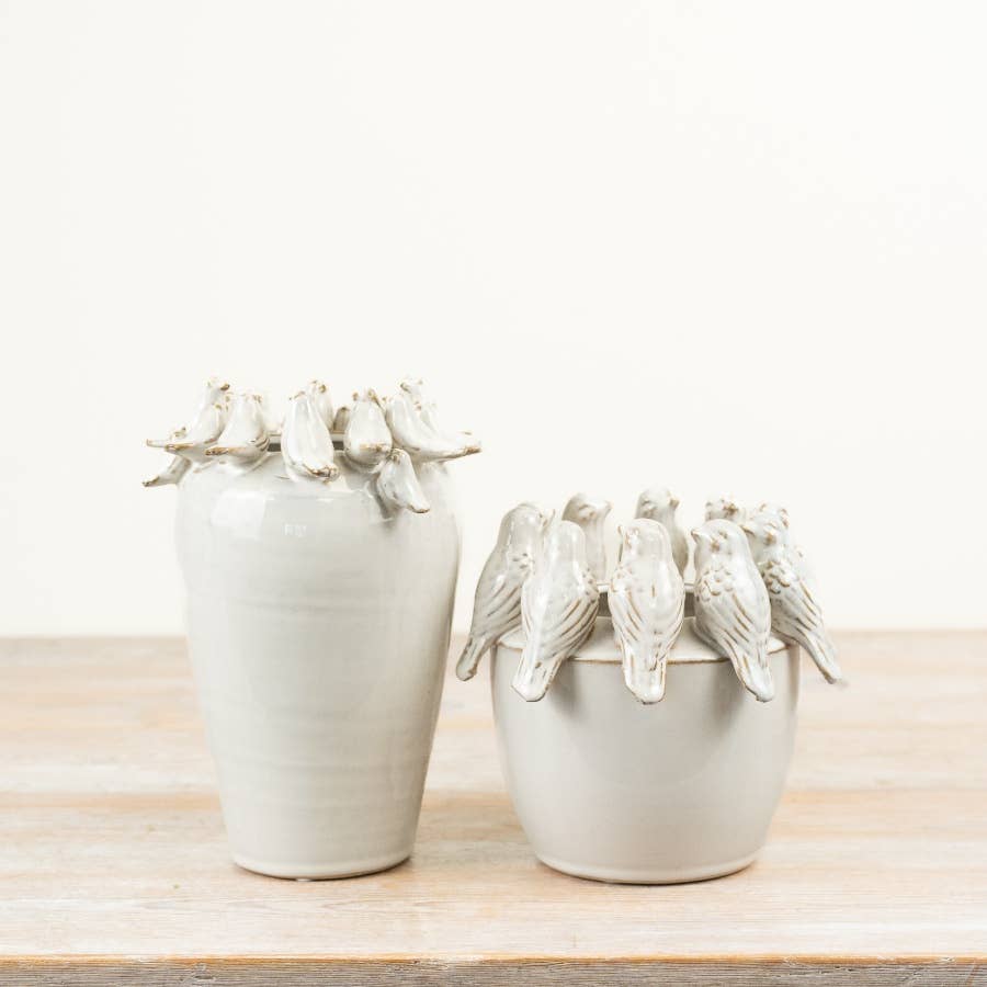Two neutral ceramic planters with sculpted birds perched around the rims in different sizes