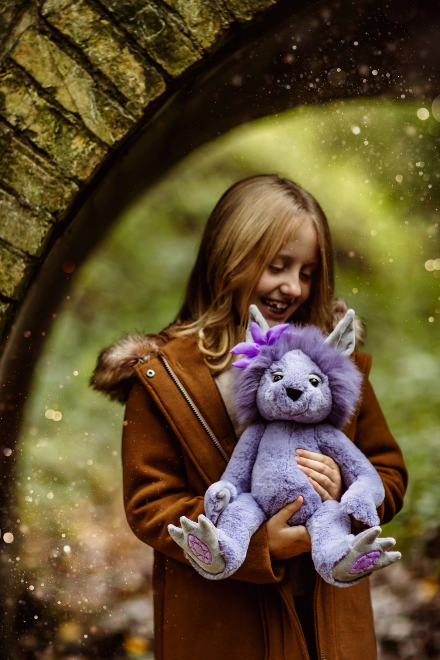 Charlie Bears Amethyst Boo plush character being cuddled in a cosy woodland lifestyle setting