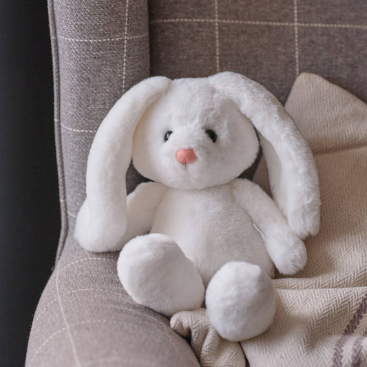 Charlie Bears Bramble Bunny white plush rabbit sitting on a soft neutral armchair