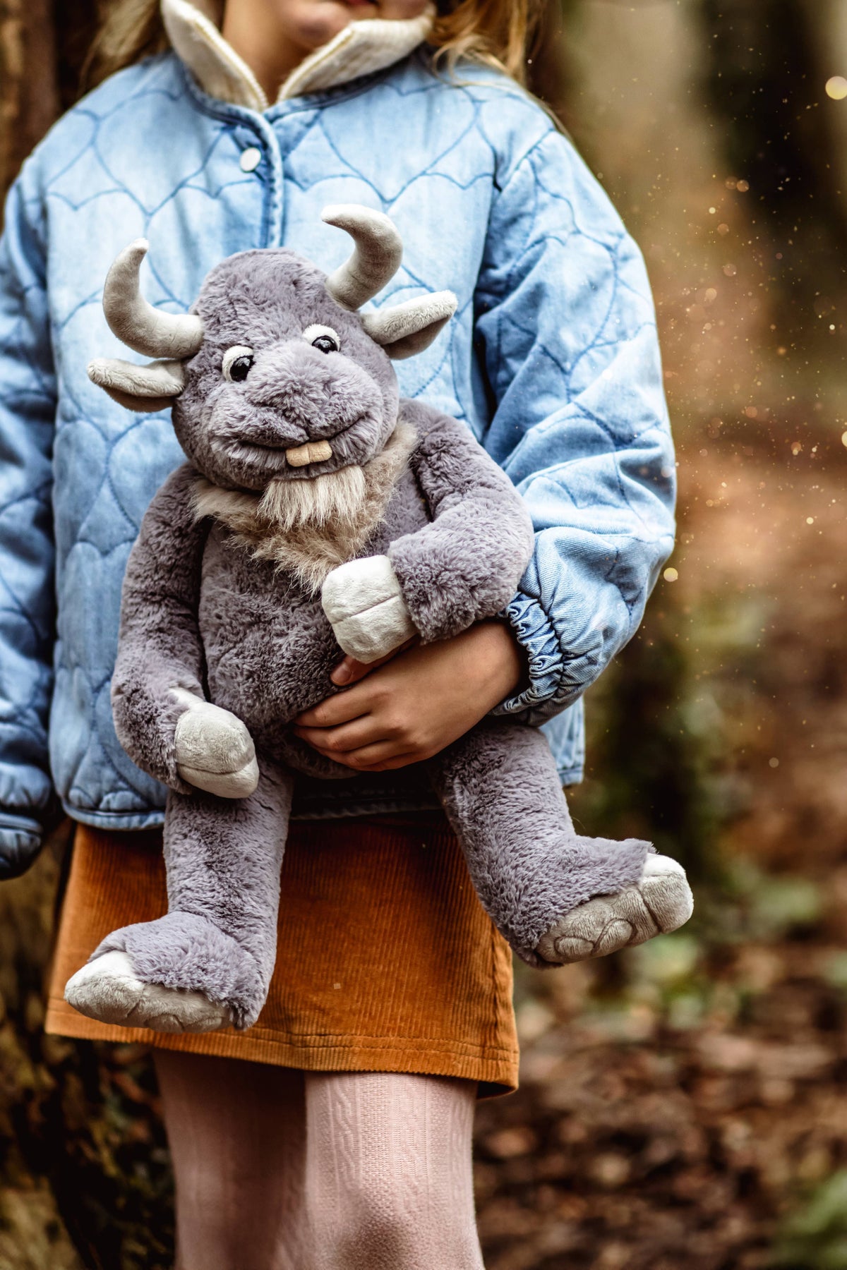 Charlie Bears Cobblestone grey giant plush toy being cuddled by a child outdoors