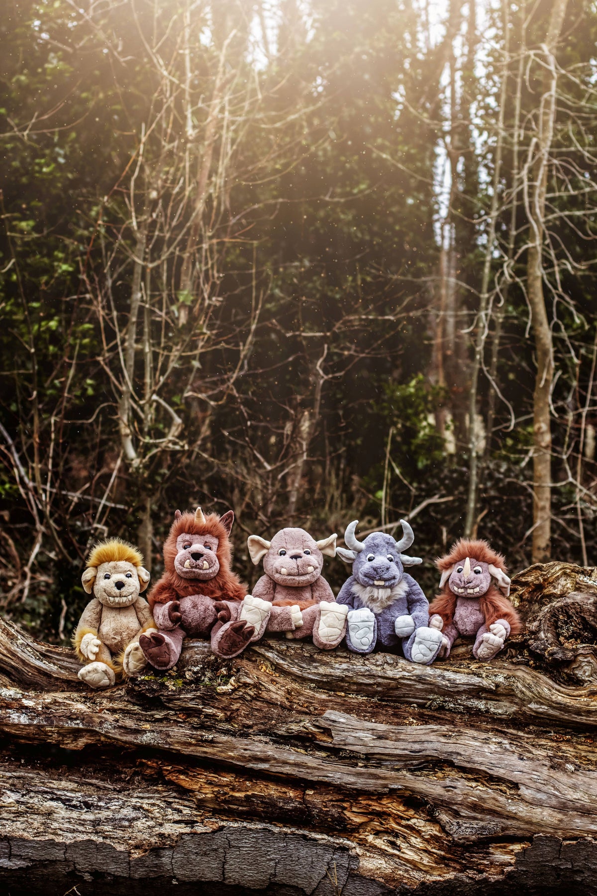 Charlie Bears Cobblestone displayed with other colourful Bearhouse mythical creatures on a fallen woodland tree