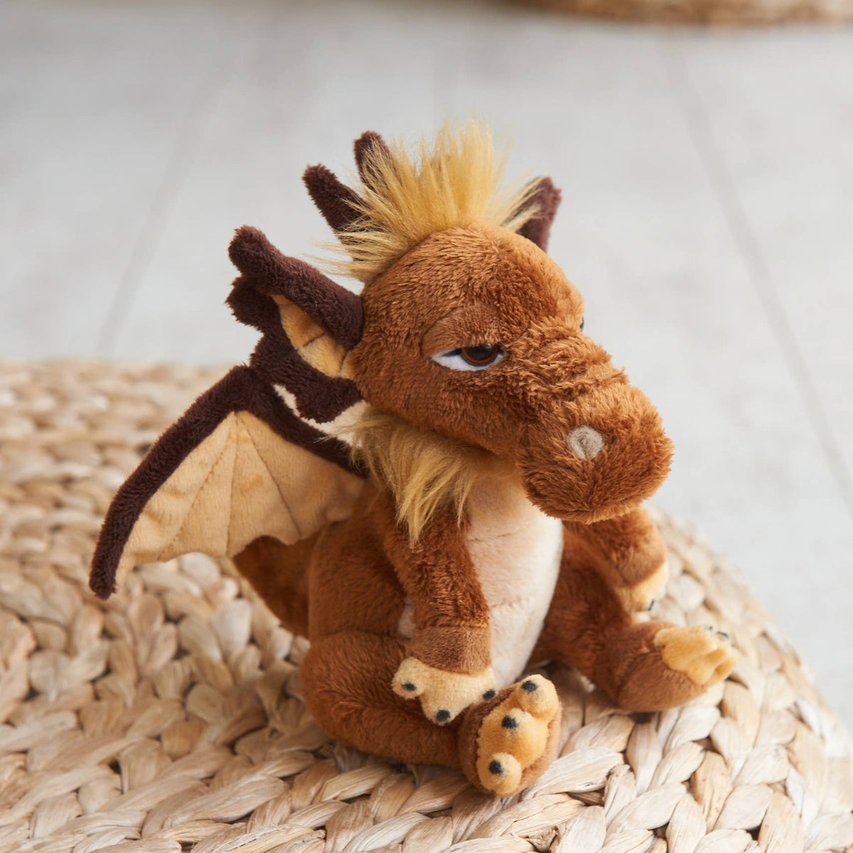 Charlie Bears Cuddle Cub Lantern brown plush dragon in a softly styled setting