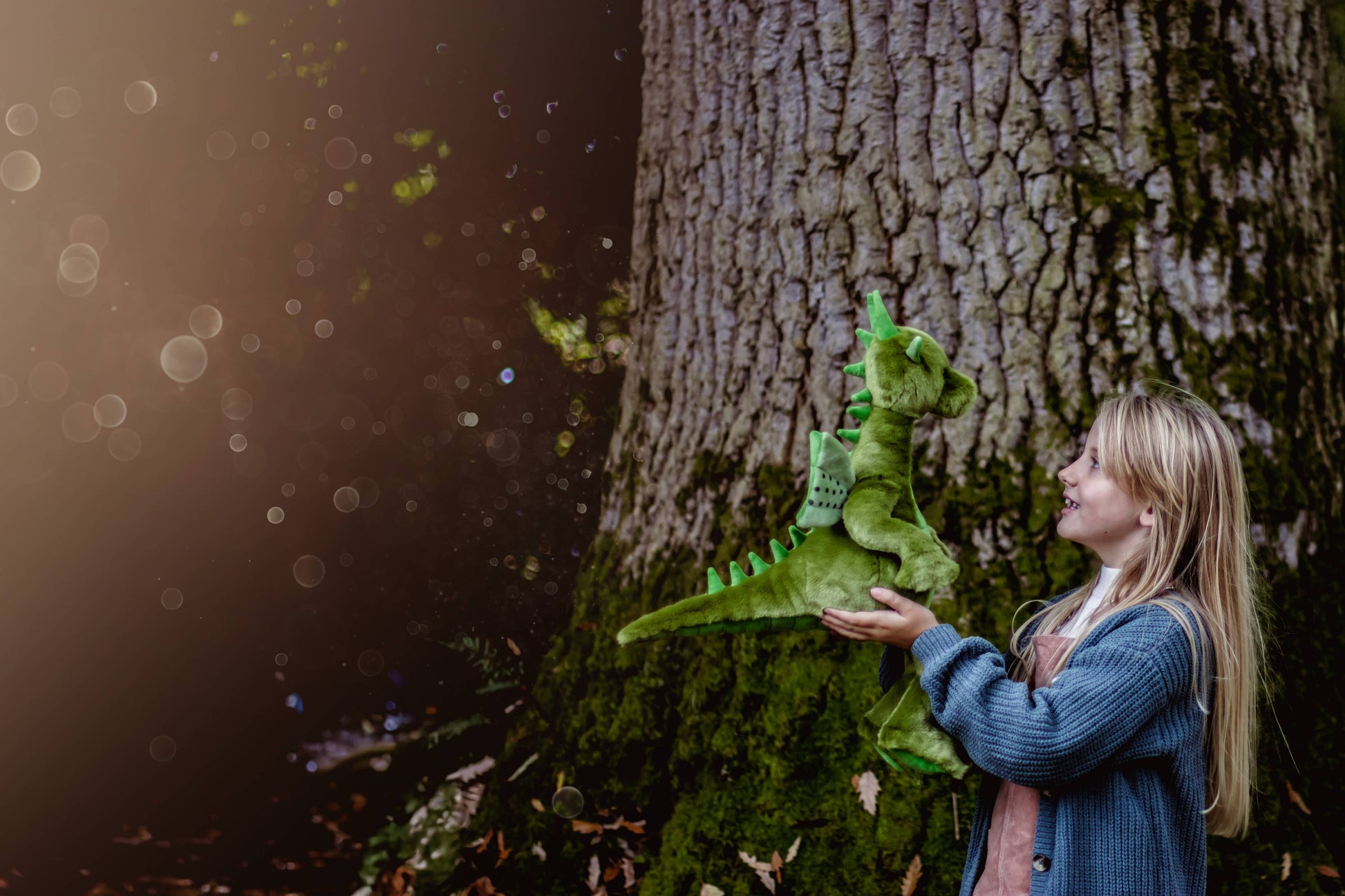 Charlie Bears Deck dragon plush being cuddled in an outdoor lifestyle setting
