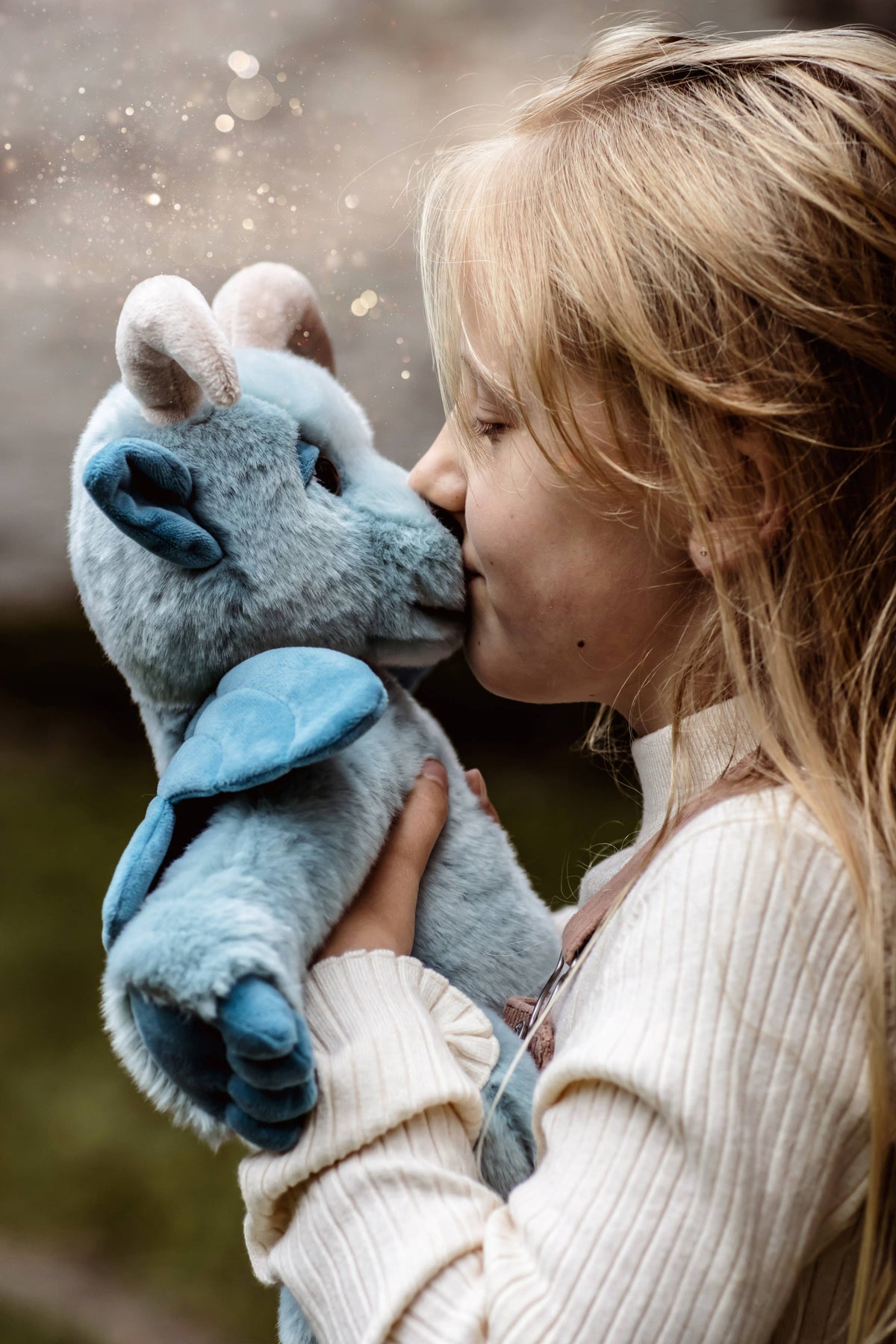 Charlie Bears Drawbridge blue plush gargoyle being cuddled by a child