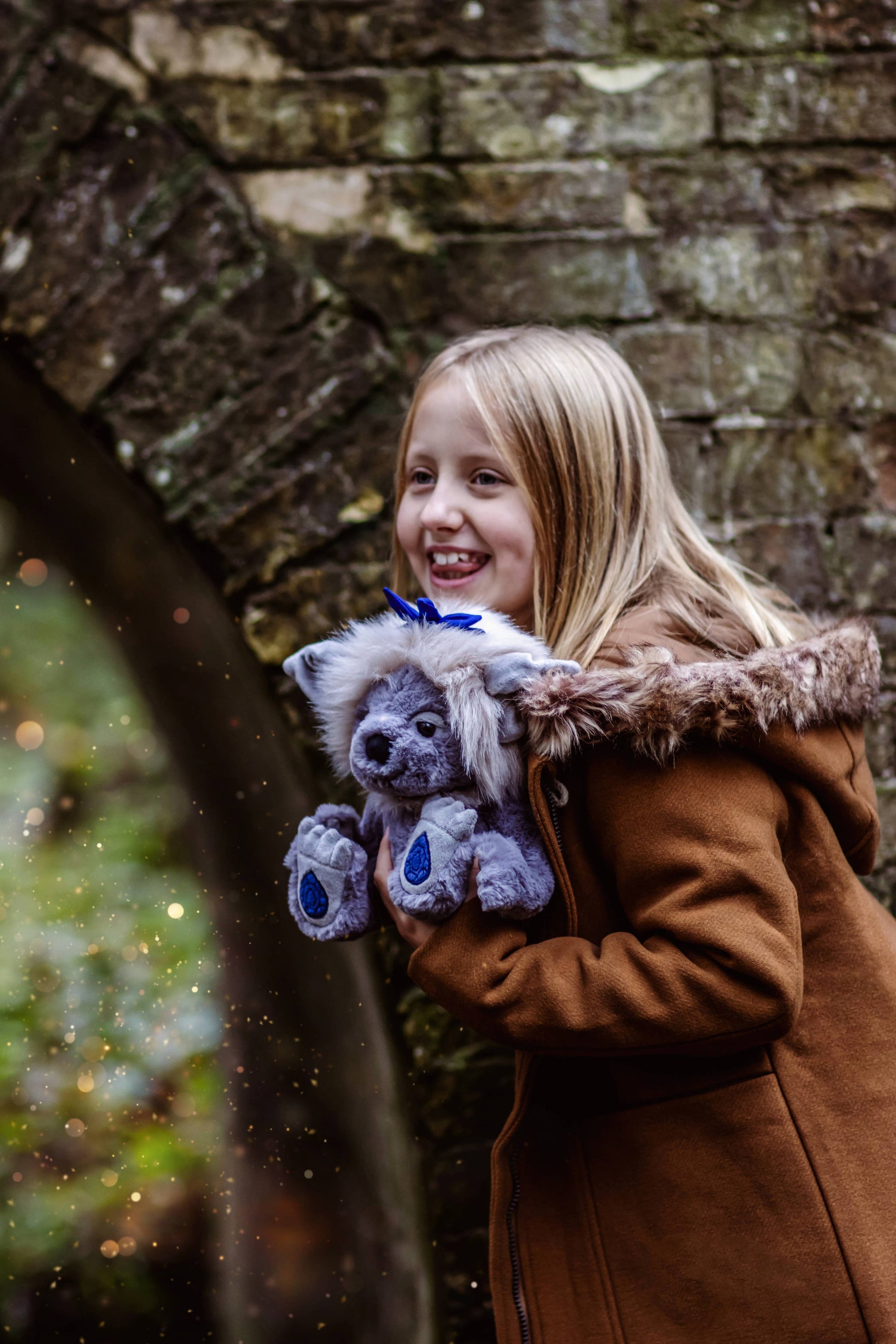 Charlie Bears Sapphire Sue plush character being cuddled in a magical woodland lifestyle setting