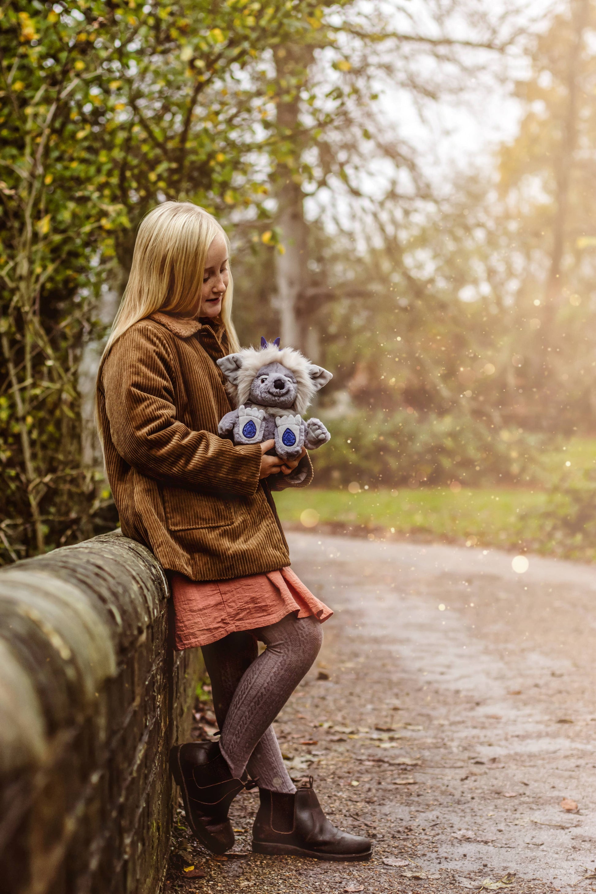 Charlie Bears Sapphire Sue plush character being cuddled in a magical woodland lifestyle setting