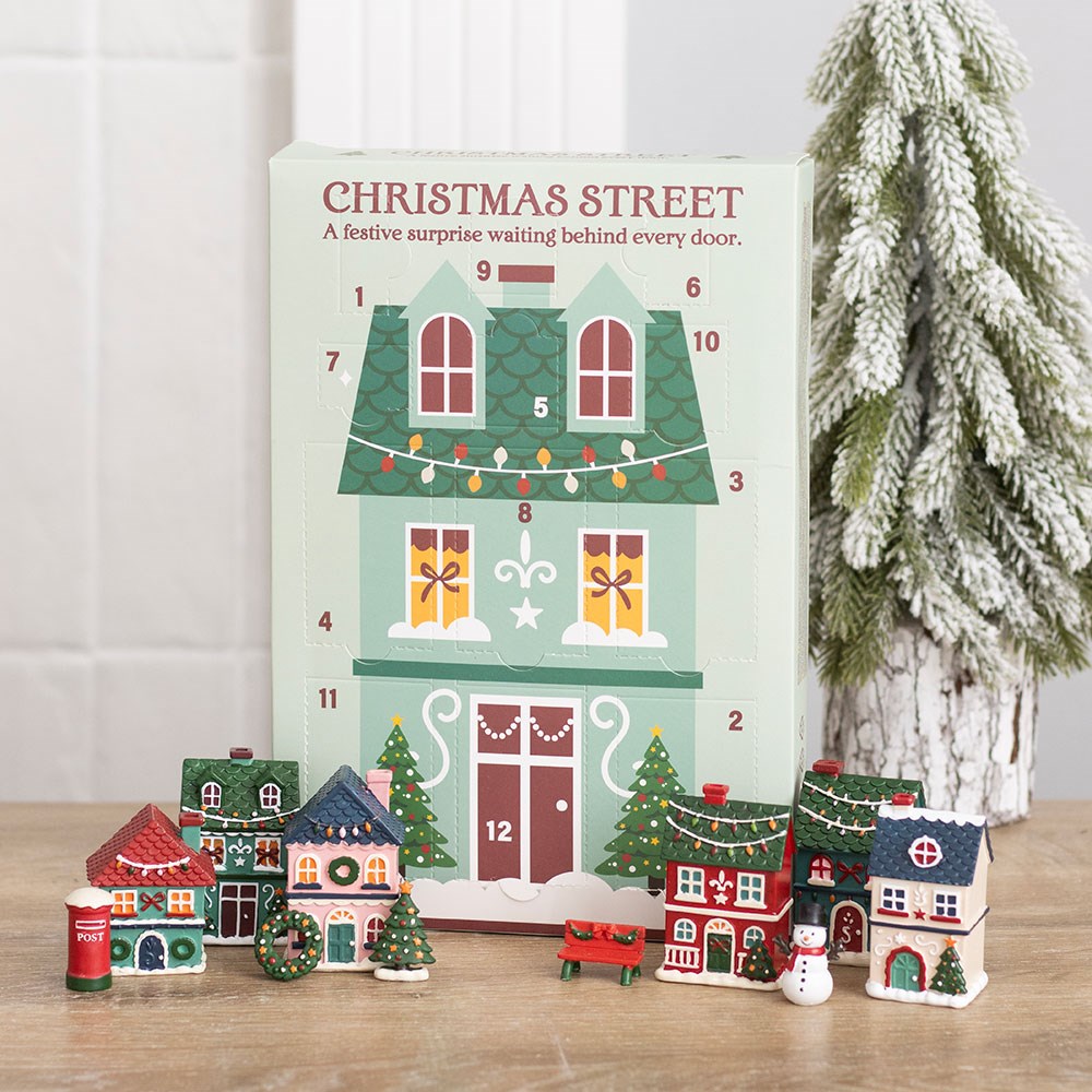 12-Day Christmas Street Scene Advent Calendar displayed with miniature festive village houses and a snowy Christmas tree