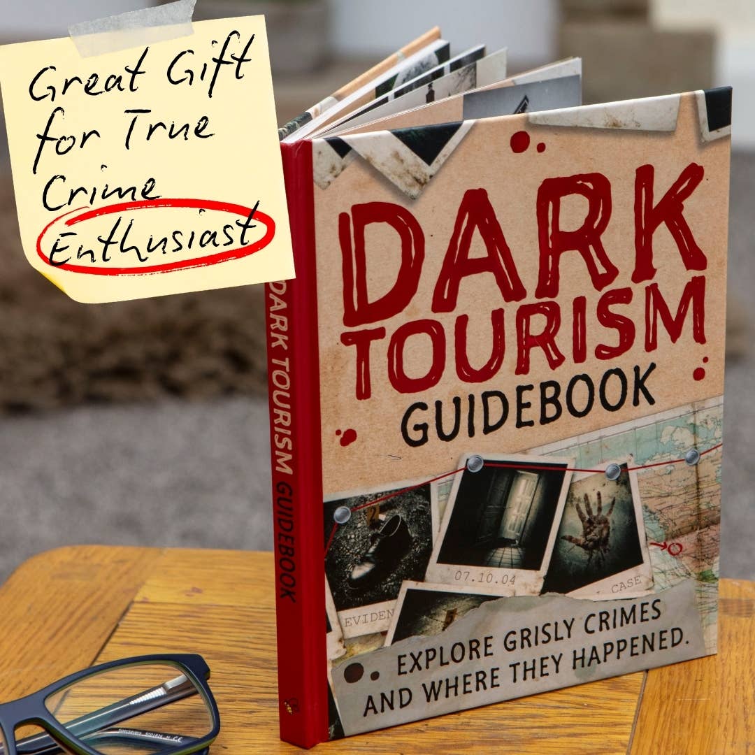 Dark Tourism Guidebook displayed with its distinctive red and cream cover, featuring crime scene imagery and travel-inspired artwork.