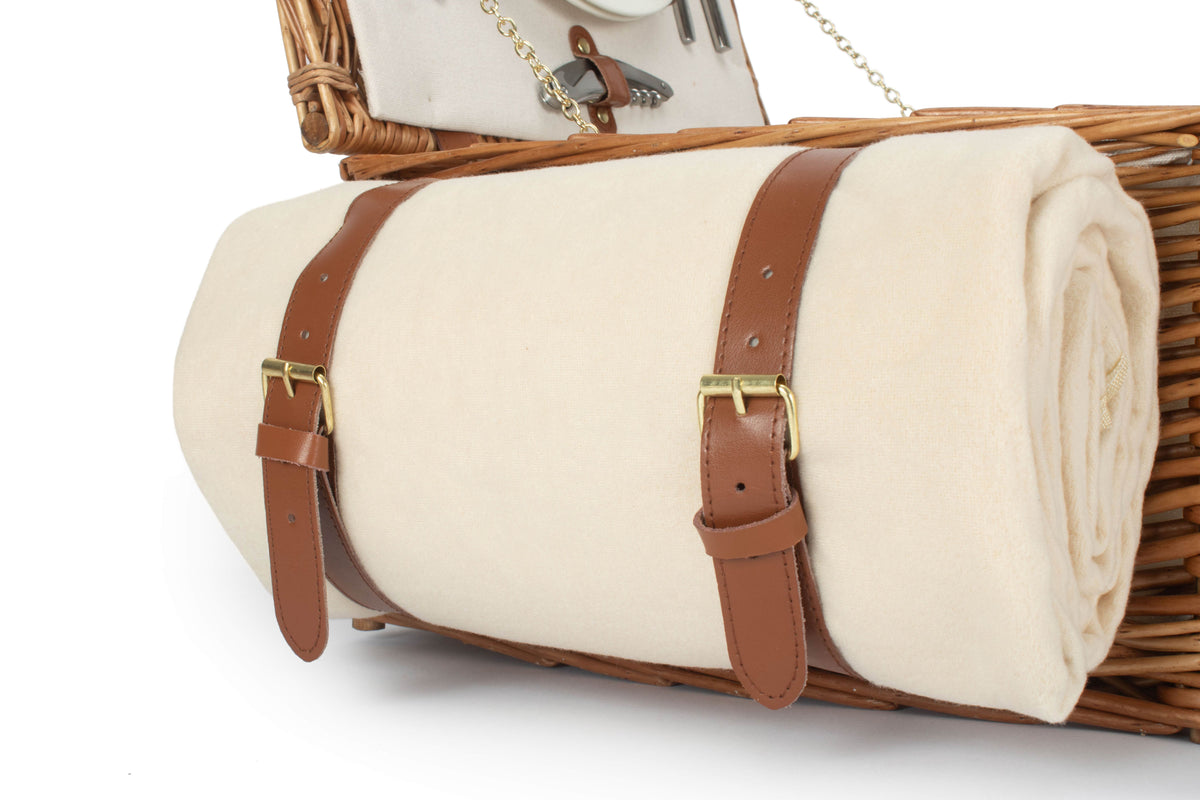 Rolled cream picnic rug with tan fastening straps supplied with the two person willow picnic hamper