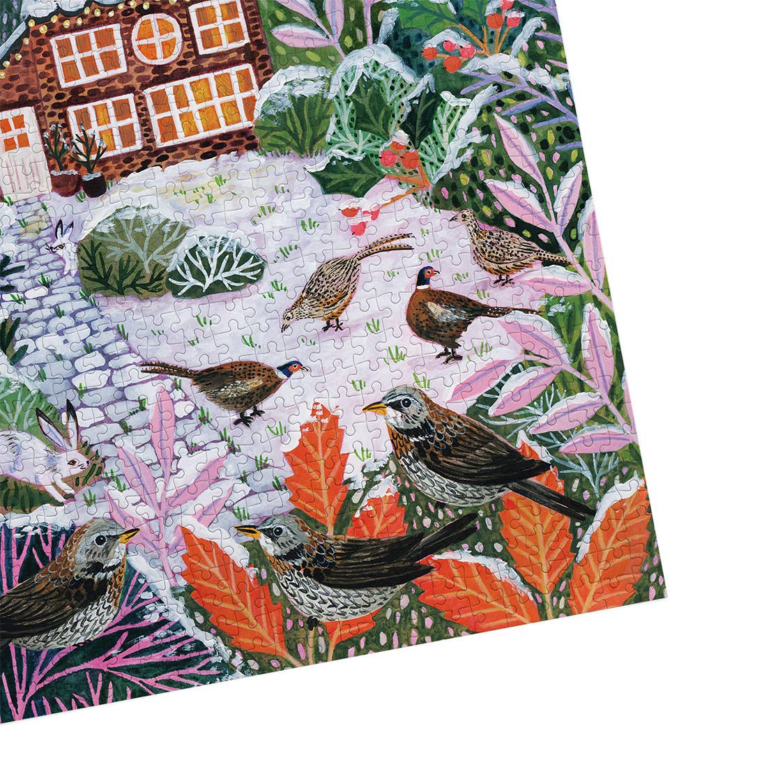 Frosty Fauna Gibsons jigsaw puzzle photographed at an angle, showing the completed snowy cottage scene and interlocking puzzle pieces.