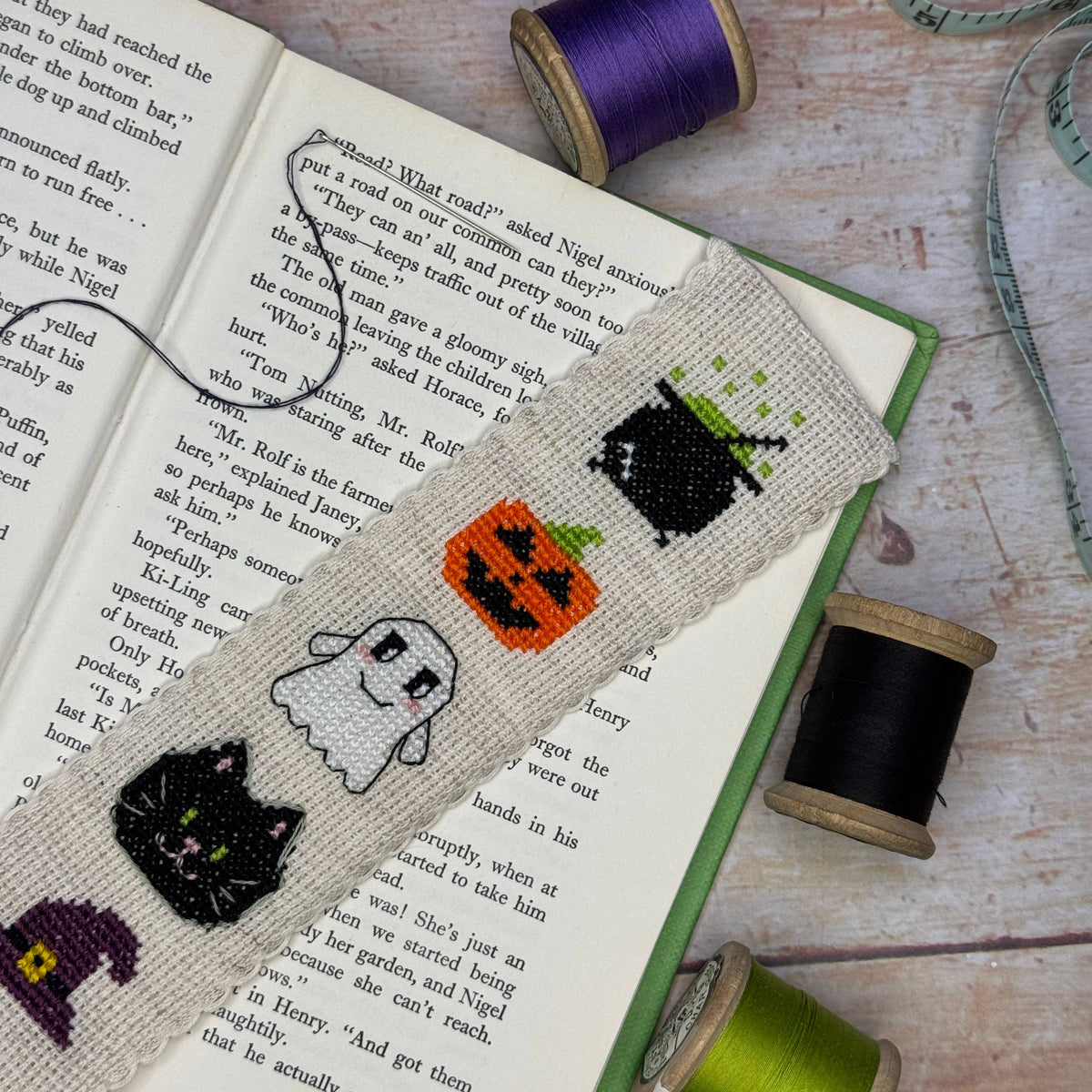 Hallowe'en Cross Stitch Bookmark Kit finished embroidered bookmark marking the pages of an open book