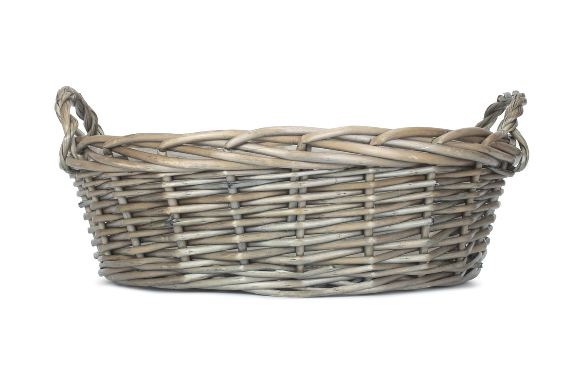 Large round antique wash willow display basket side view showing the shallow shape, rustic weave and carrying handles