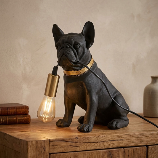 Matt black and gold pug table lamp with exposed glowing bulb displayed on a characterful oak sideboard.
