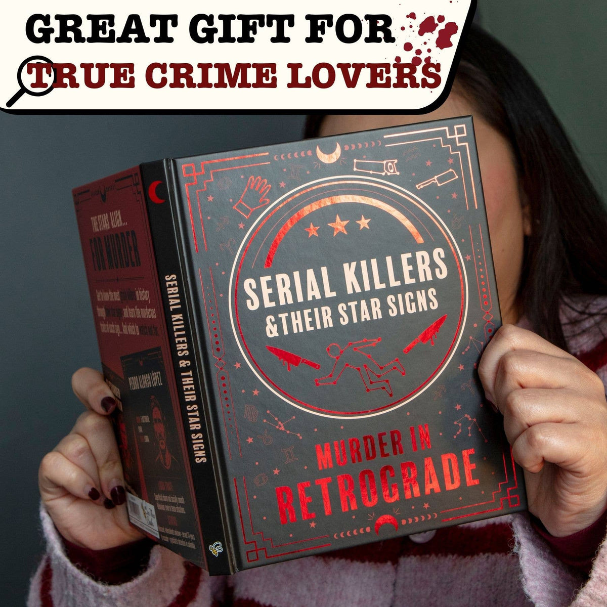 Murder in Retrograde hardback shown in hand as an unusual gift book for true crime lovers