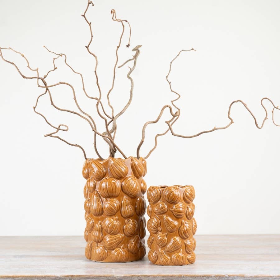 Close-up of autumn branches displayed in orange pumpkin ceramic vase