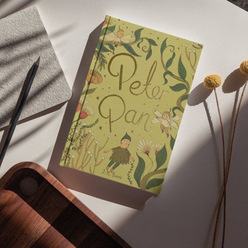 Peter Pan Wordsworth Collector's Edition hardback by J. M. Barrie displayed on a rustic wooden table.