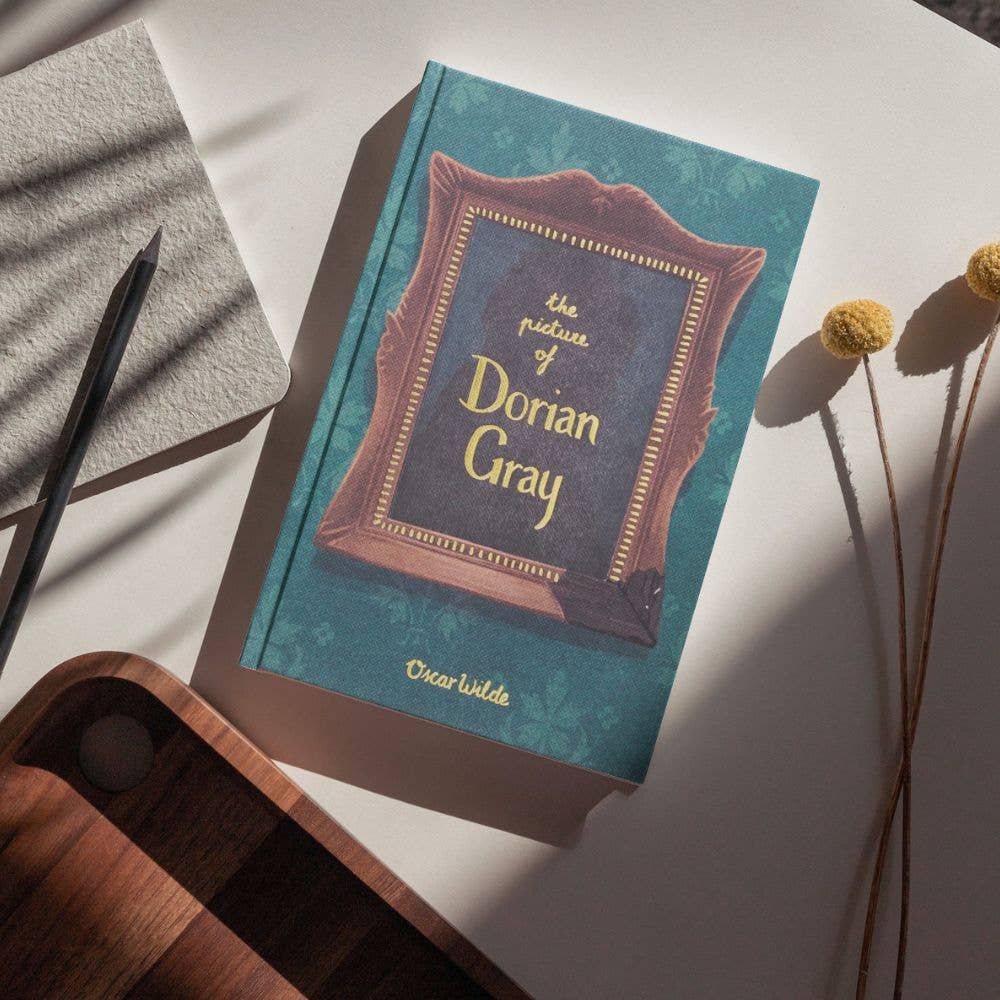The Picture of Dorian Gray Wordsworth Collector's Edition hardback by Oscar Wilde displayed on a rustic writing desk.